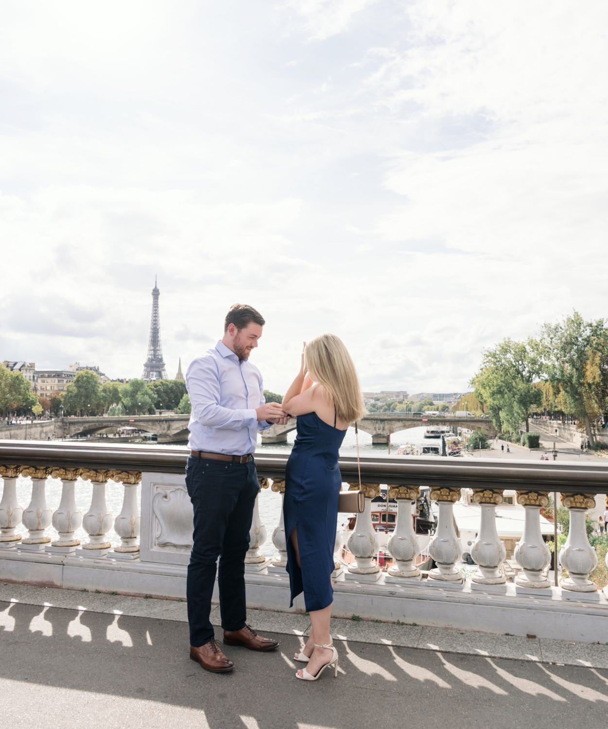 man gives engagement ring to woman with view of the eiffel tower