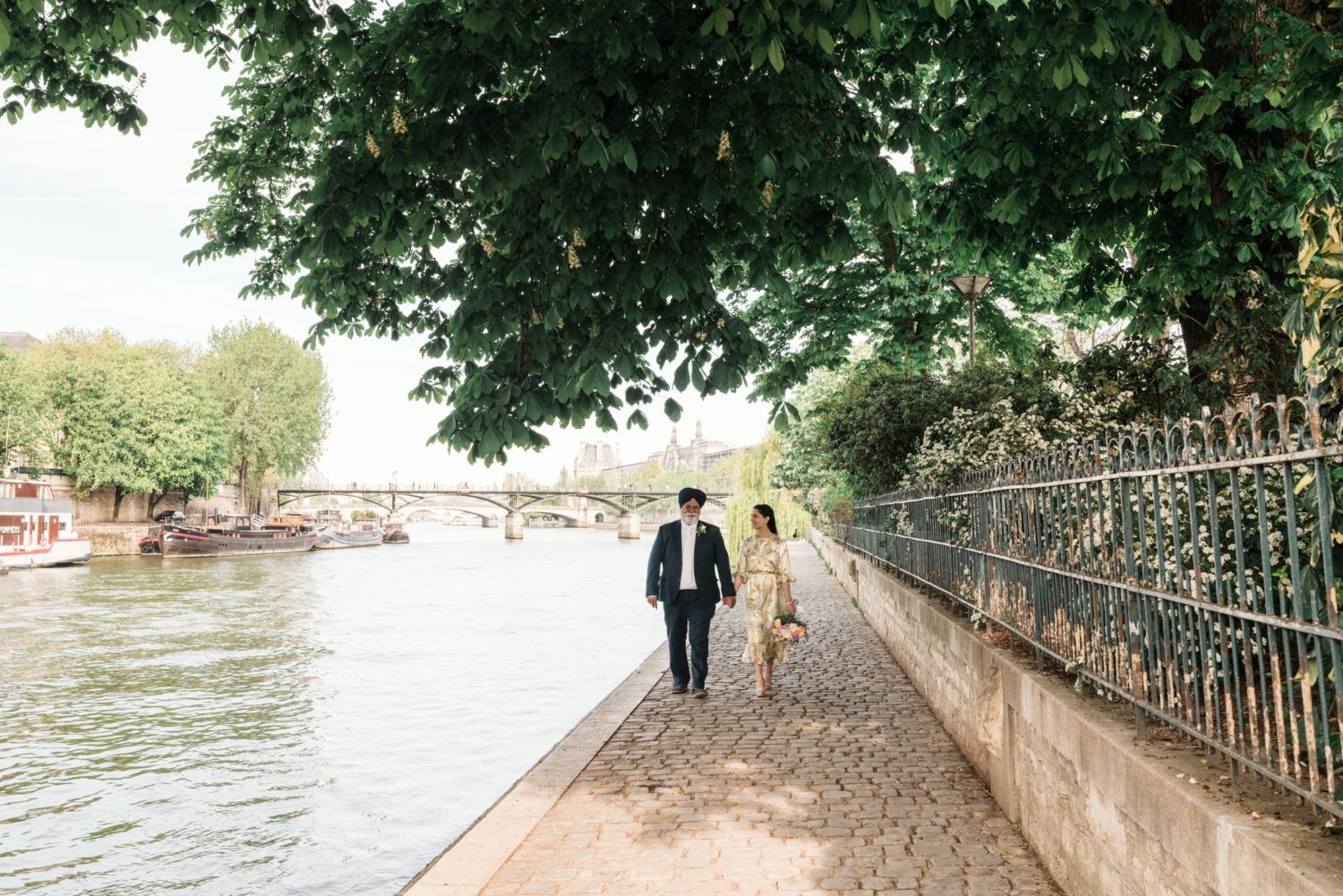 mature indian couple walk together along the river in paris france