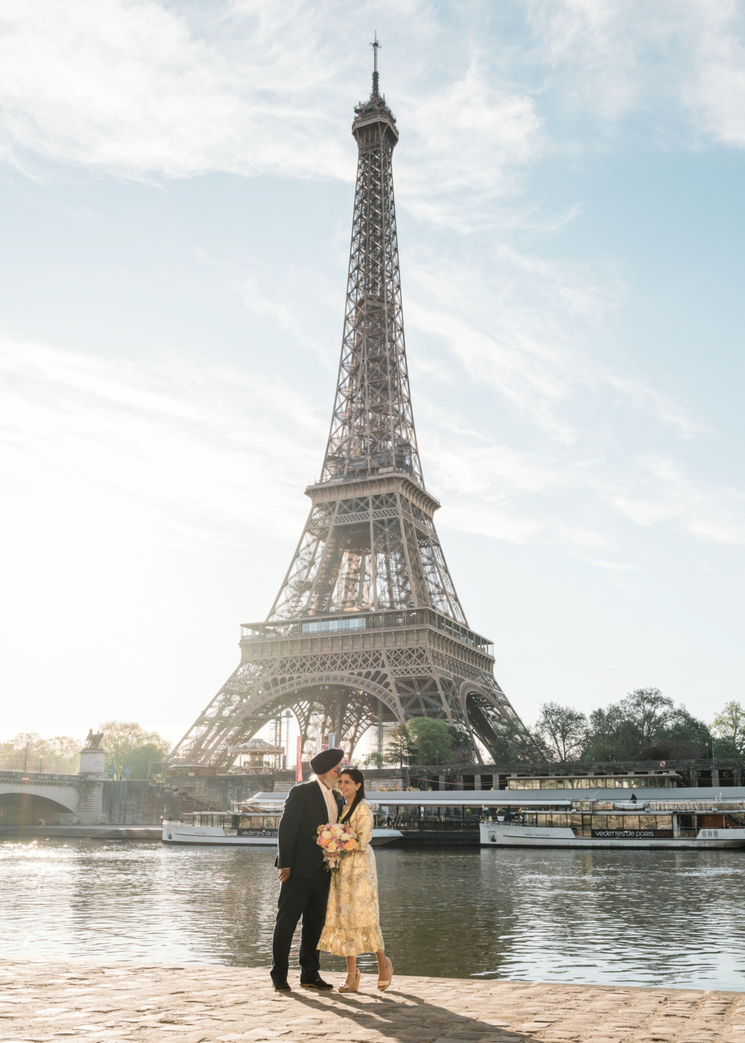 cute indian couple embrace with eiffel tower behind them in paris