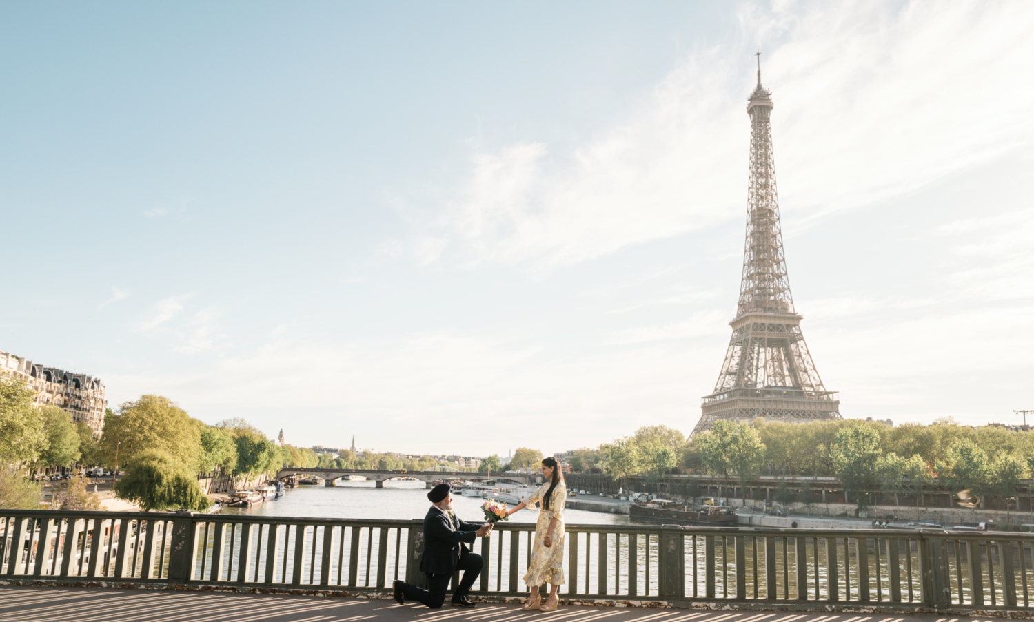 indian man presents flowers to indian woman with view of eiffel tower in paris