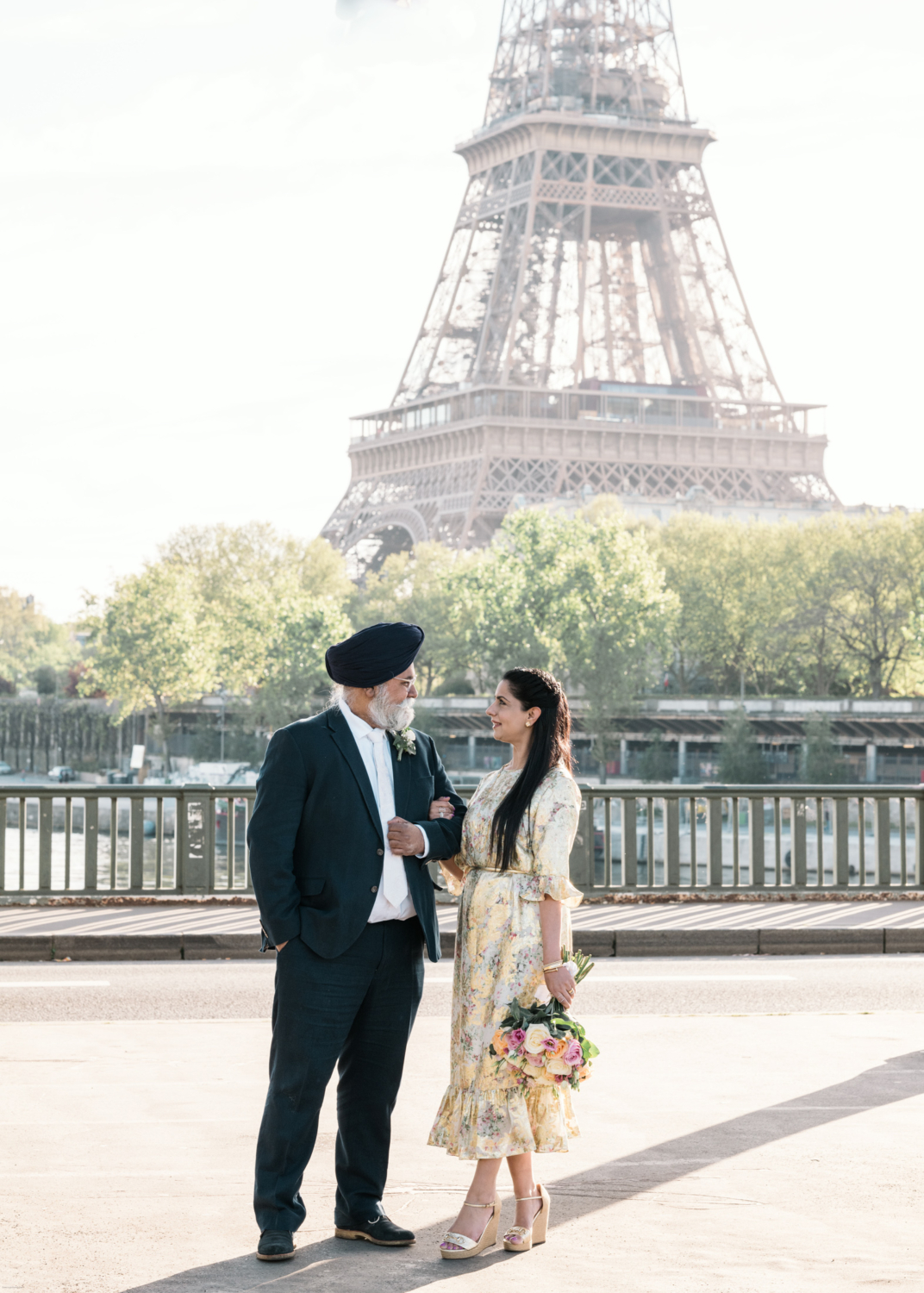 mature indian couple arm in arm with view of the eiffel tower in paris