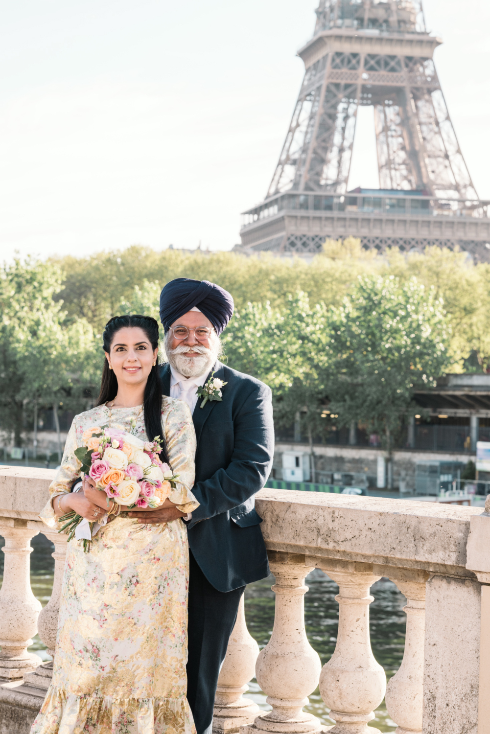 mature indian couple pose during photoshoot with view of eiffel tower