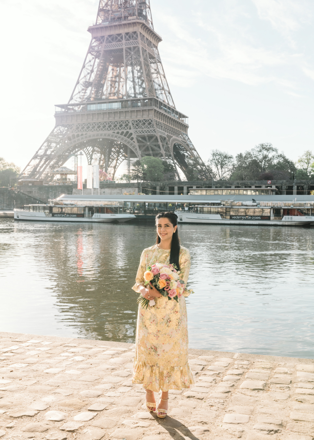 beautiful mature indian woman poses with bouquet of roses with view of eiffel tower