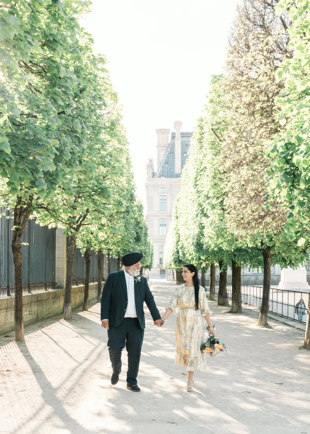 mature indian couple walk hand in hand in tuileries gardens in paris