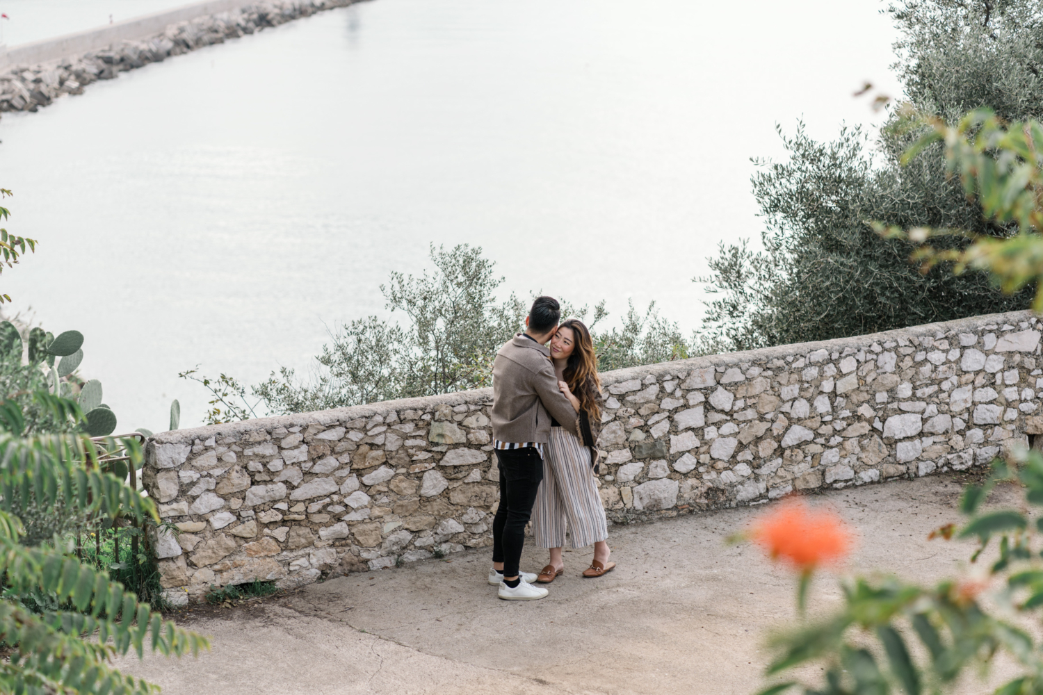 newly engaged couple embrace with view of sea in nice, france