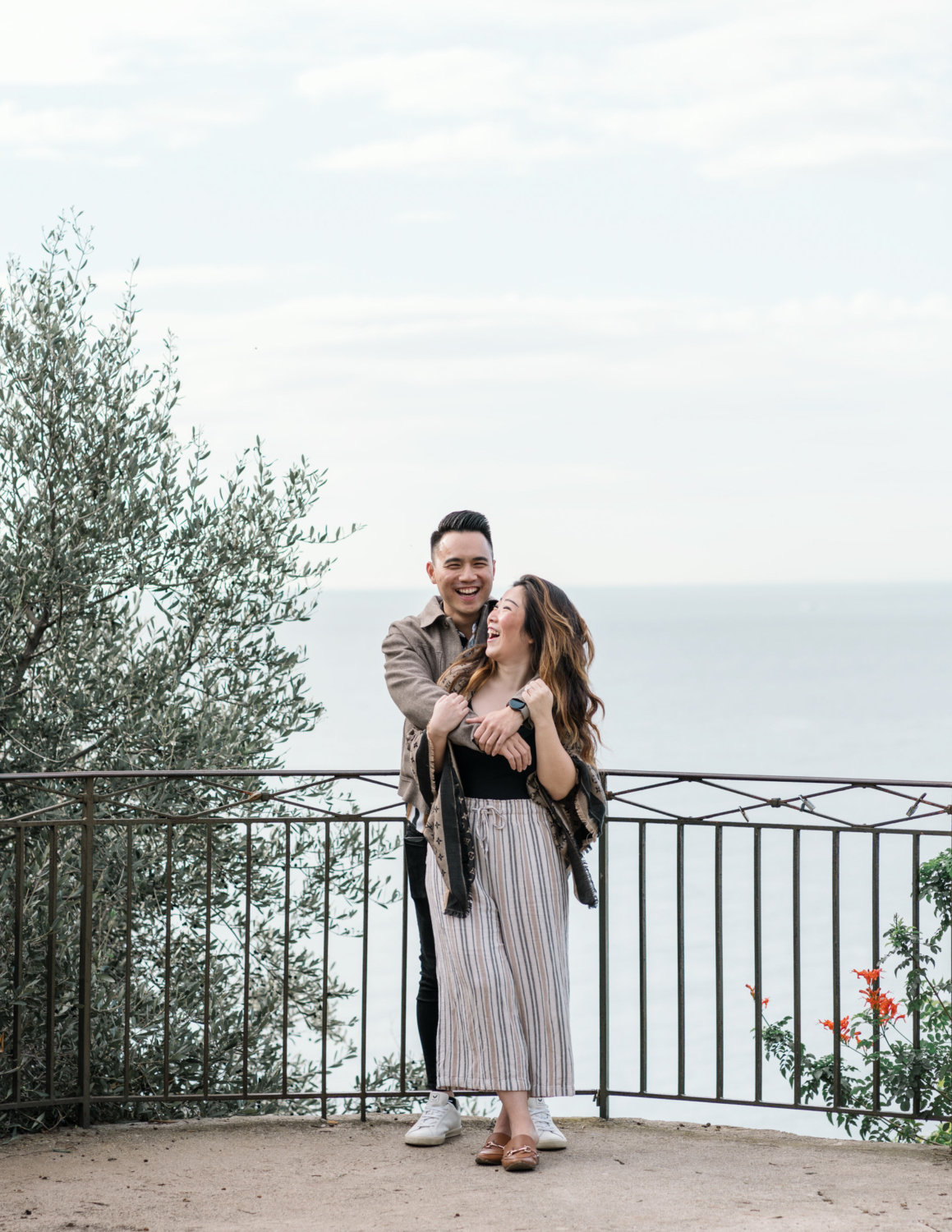 newly engaged couple laugh together with view of sea in nice, france