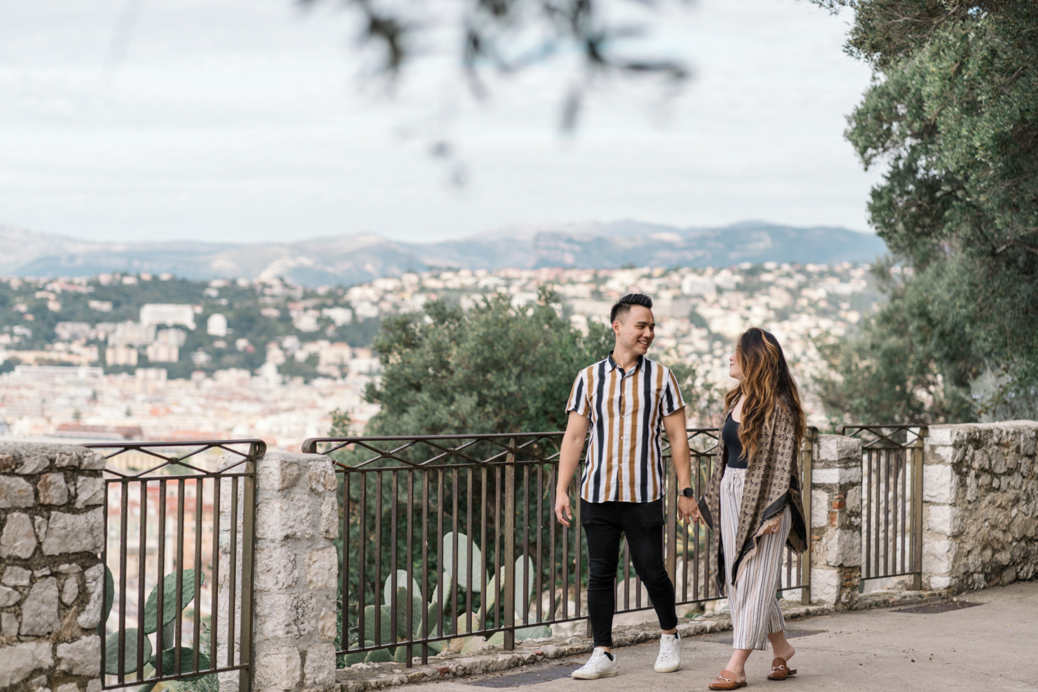 newly engaged couple take walk in garden with view in nice, france