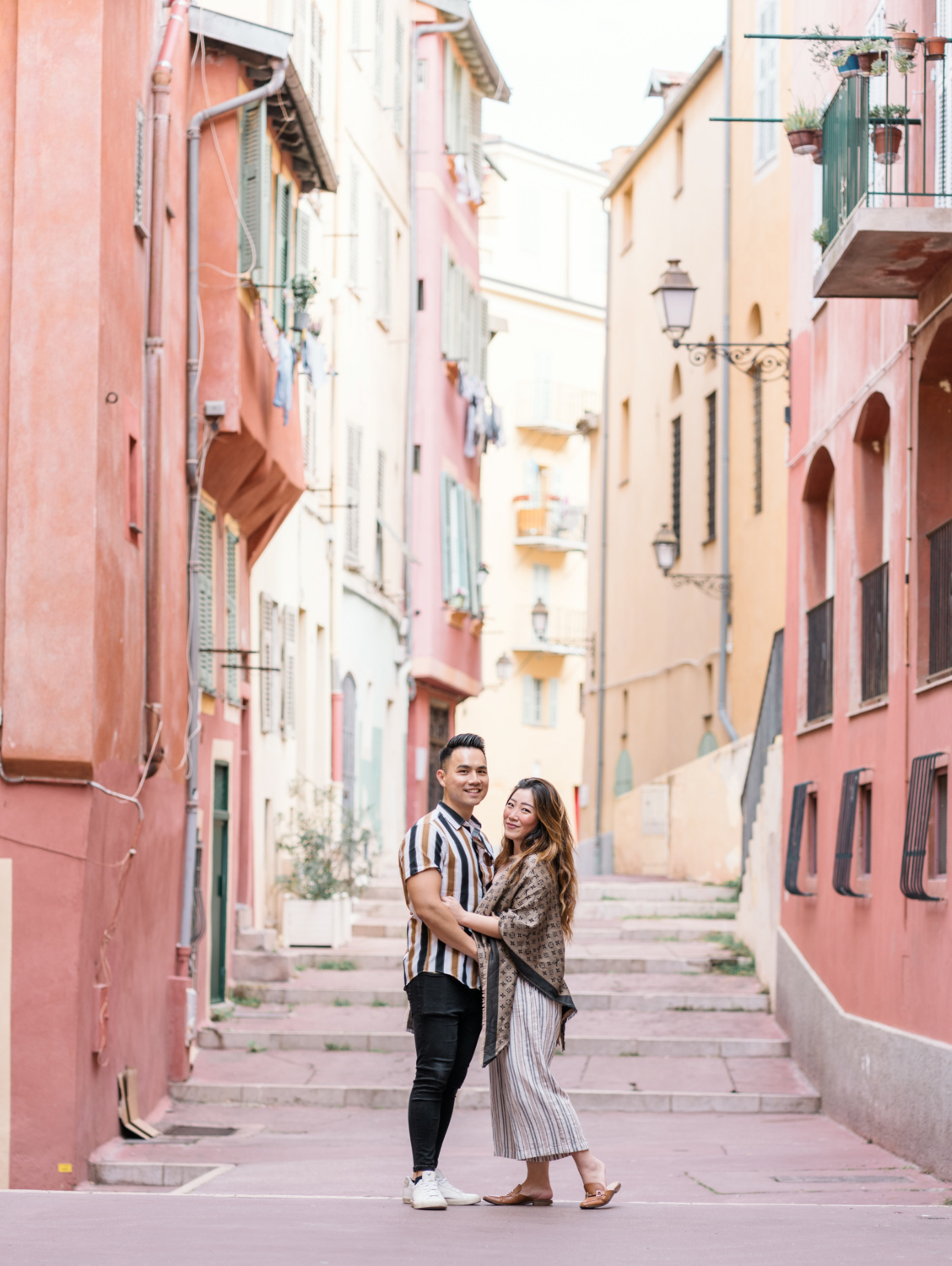 newly engaged couple kiss in colorful old town in nice, france