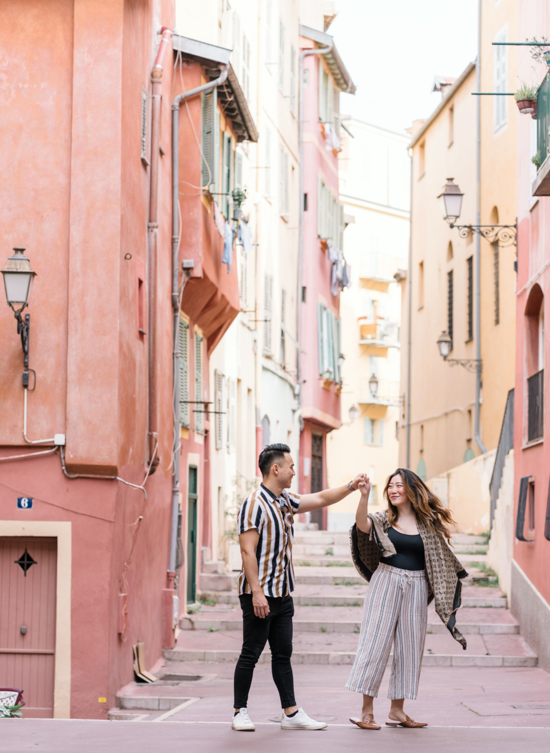 newly engaged couple dance in colorful old town nice france