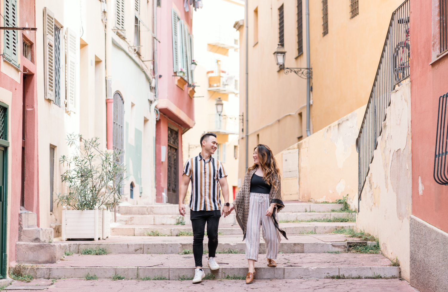 newly engaged couple smile as they walk through streets of old town nice