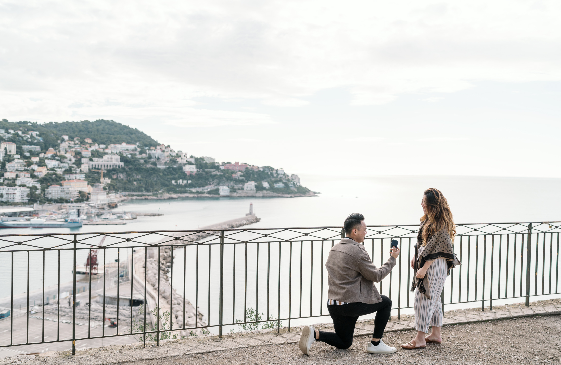 woman smiles as man presents diamond ring to woman in nice france