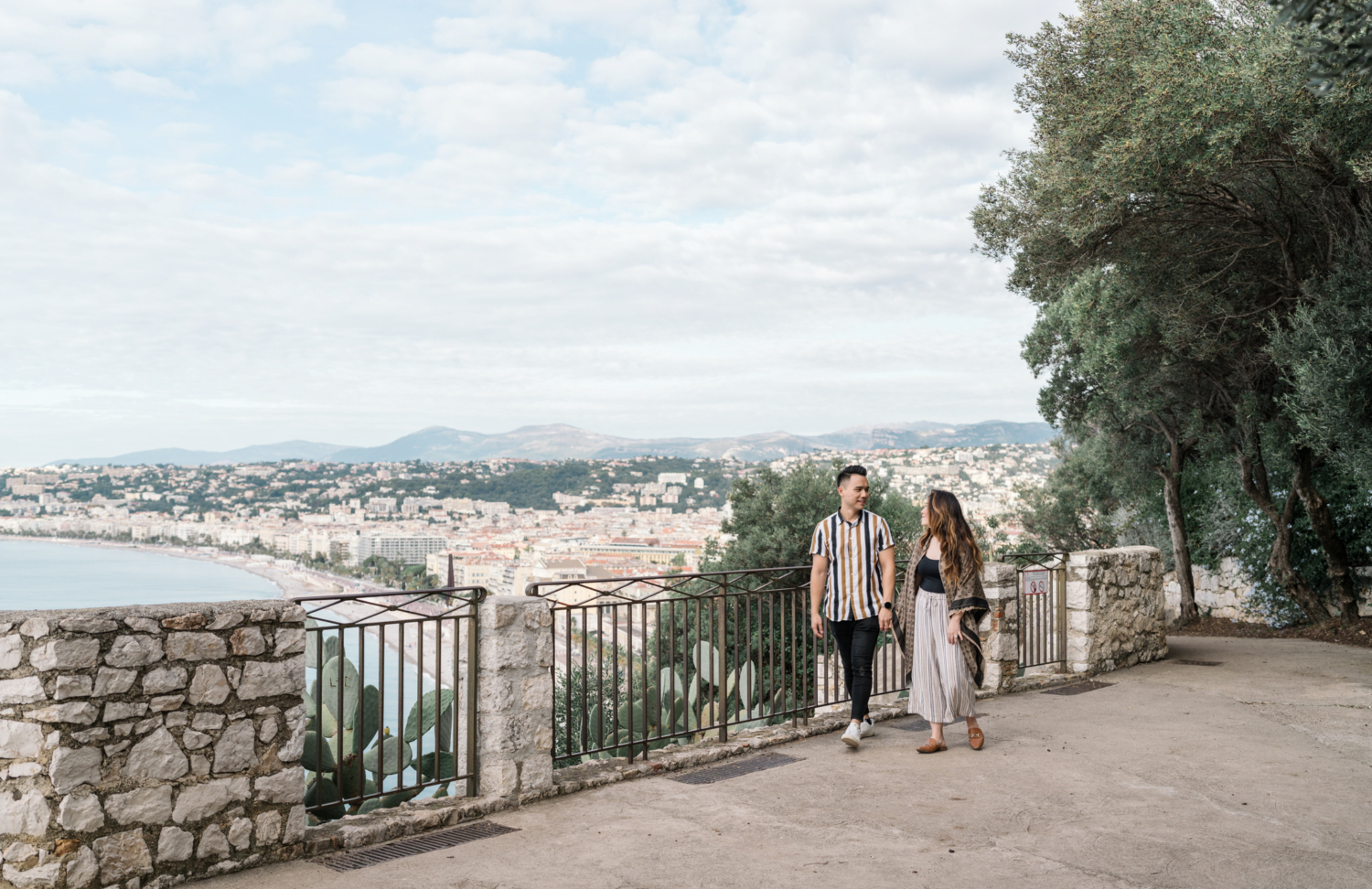 cute couple walk in nice, france garden after their engagement