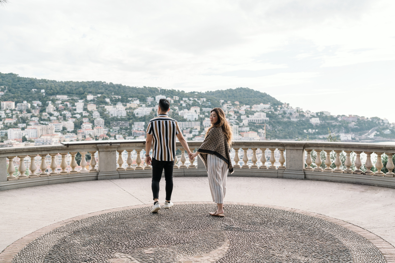 newly engaged couple walk on castle hill in nice france