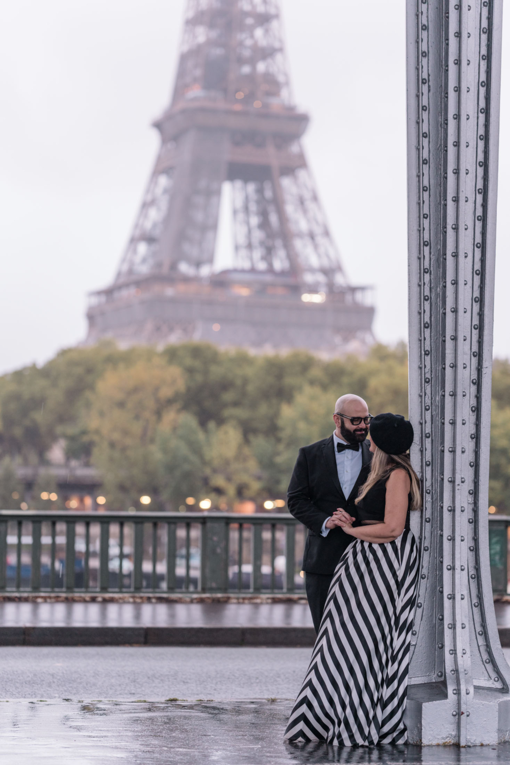 married couple pose with view of eiffel tower in background