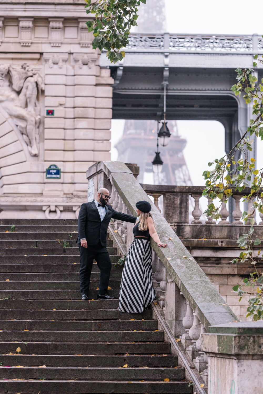 cute mature couple pose on staircase with eiffel tower in background