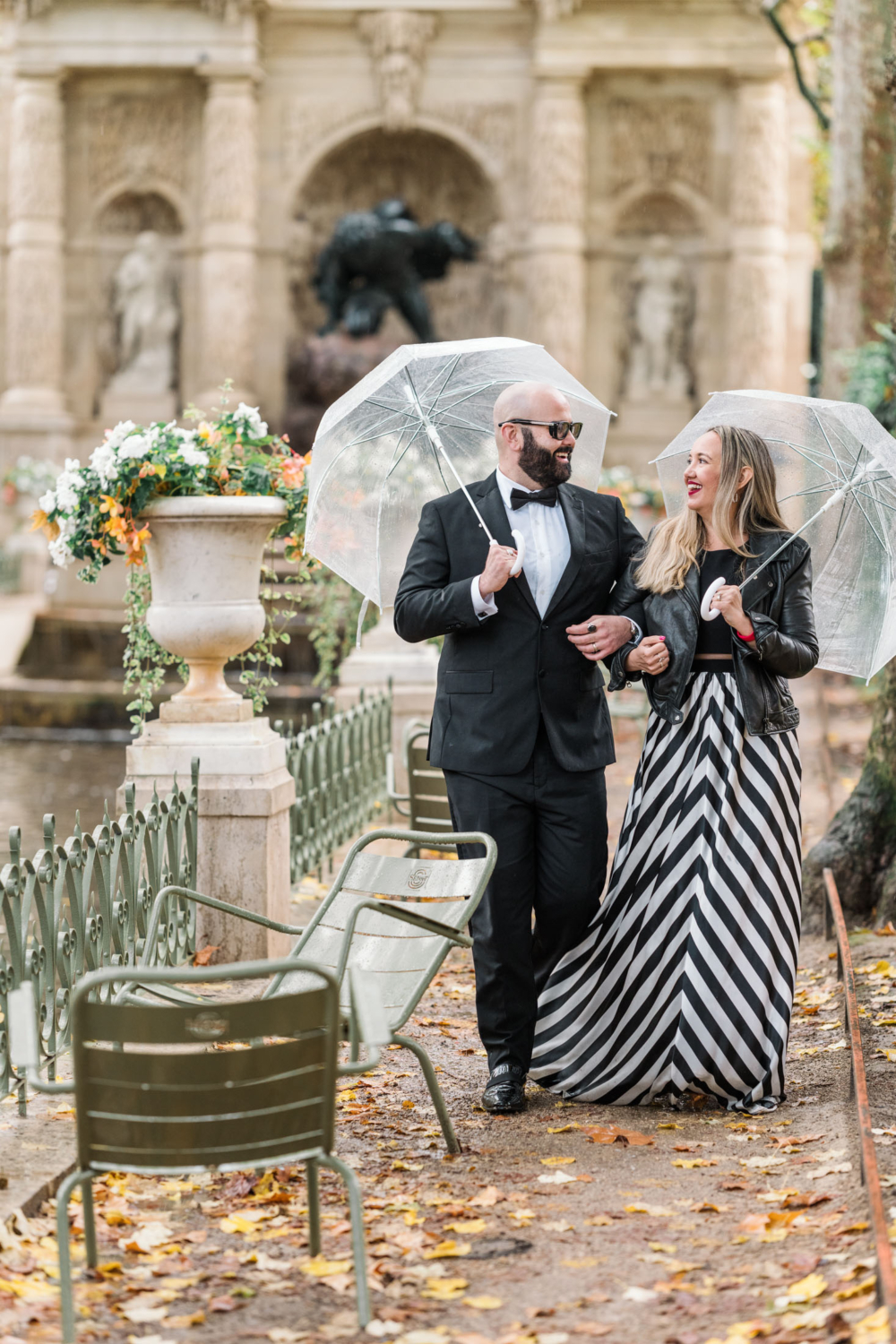 charming married couple smile and laugh in the rain in paris