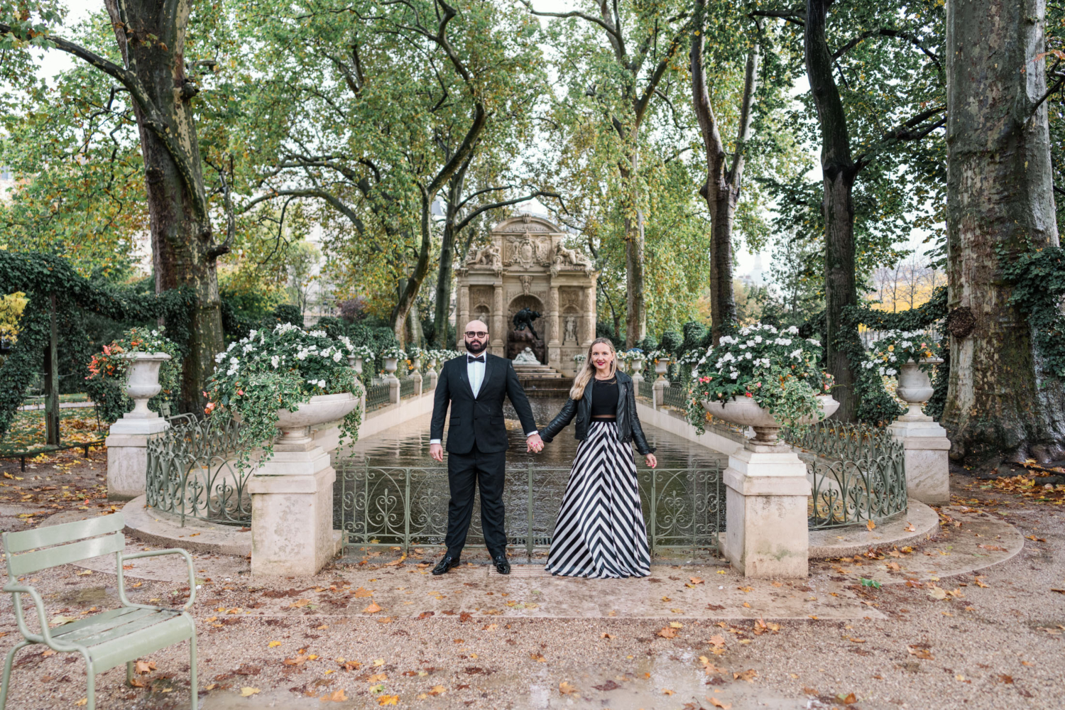 cute married couple pose in front of medici fountain in luxembourg gardens paris