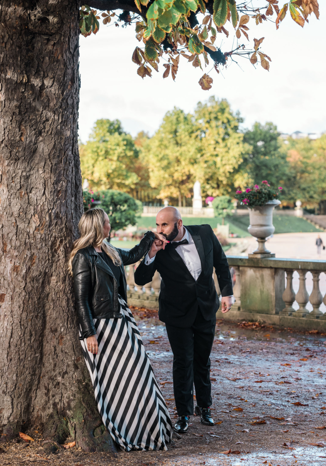 man kisses wife on hand in luxembourg gardens in paris