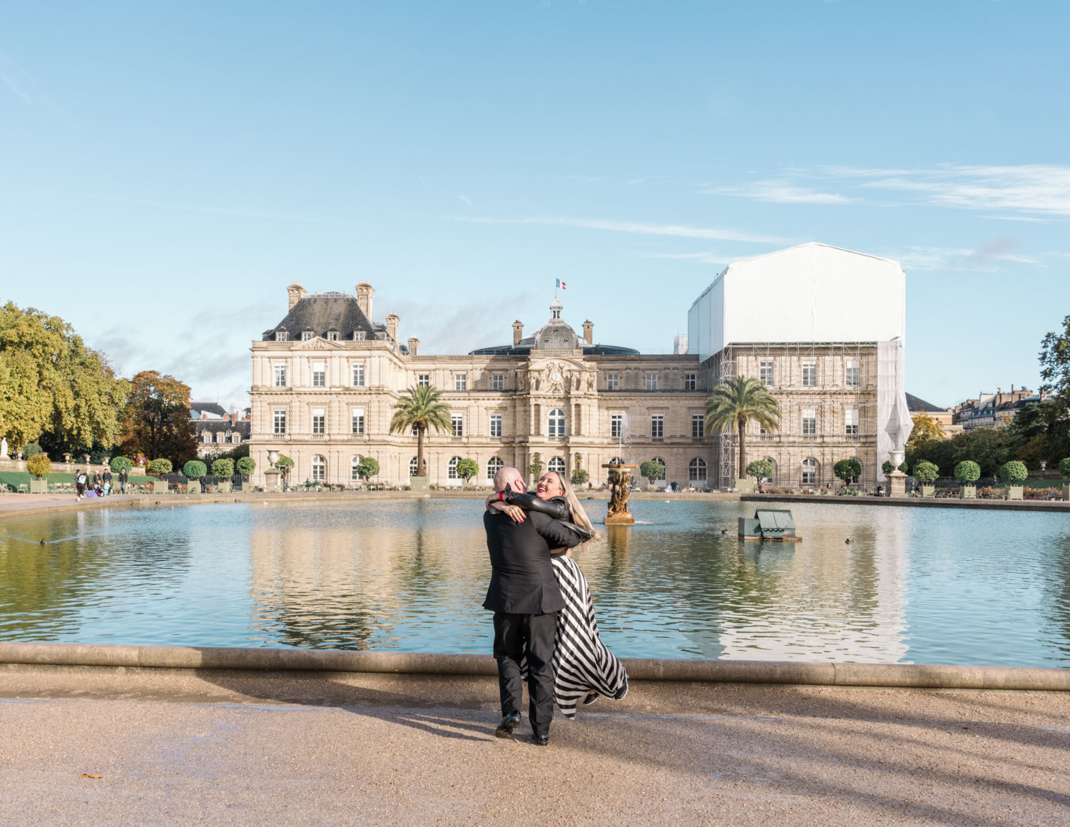 ecstatic married couple laugh and twirl in luxembourg gardens paris