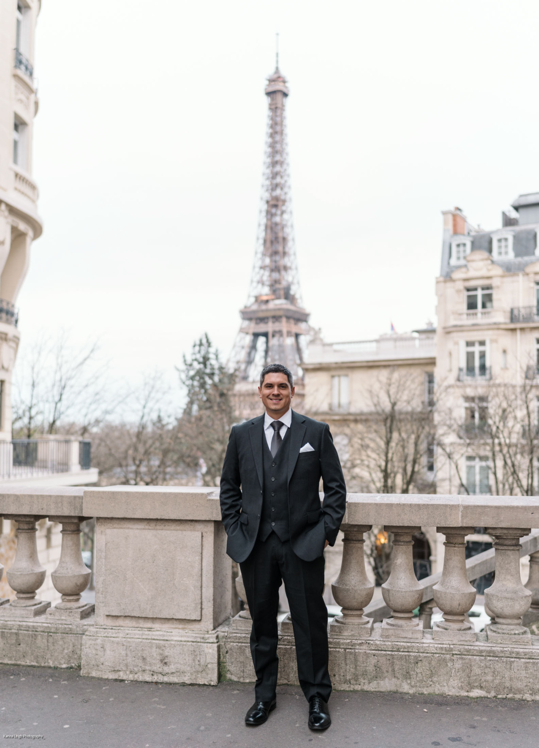 happy mature groom poses in front of eiffel tower on his wedding day