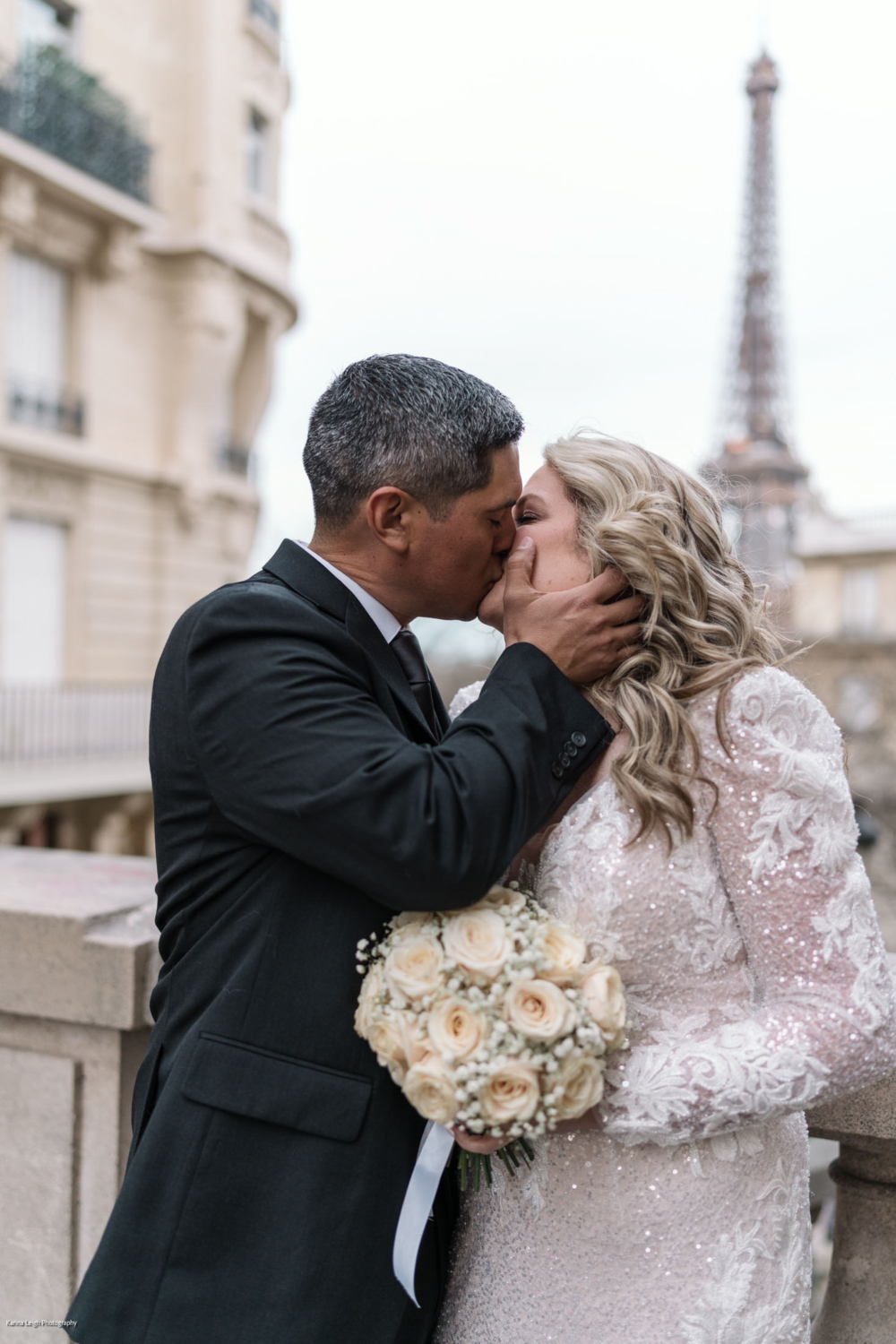 mature couple kiss passionately with view of eiffel tower in paris