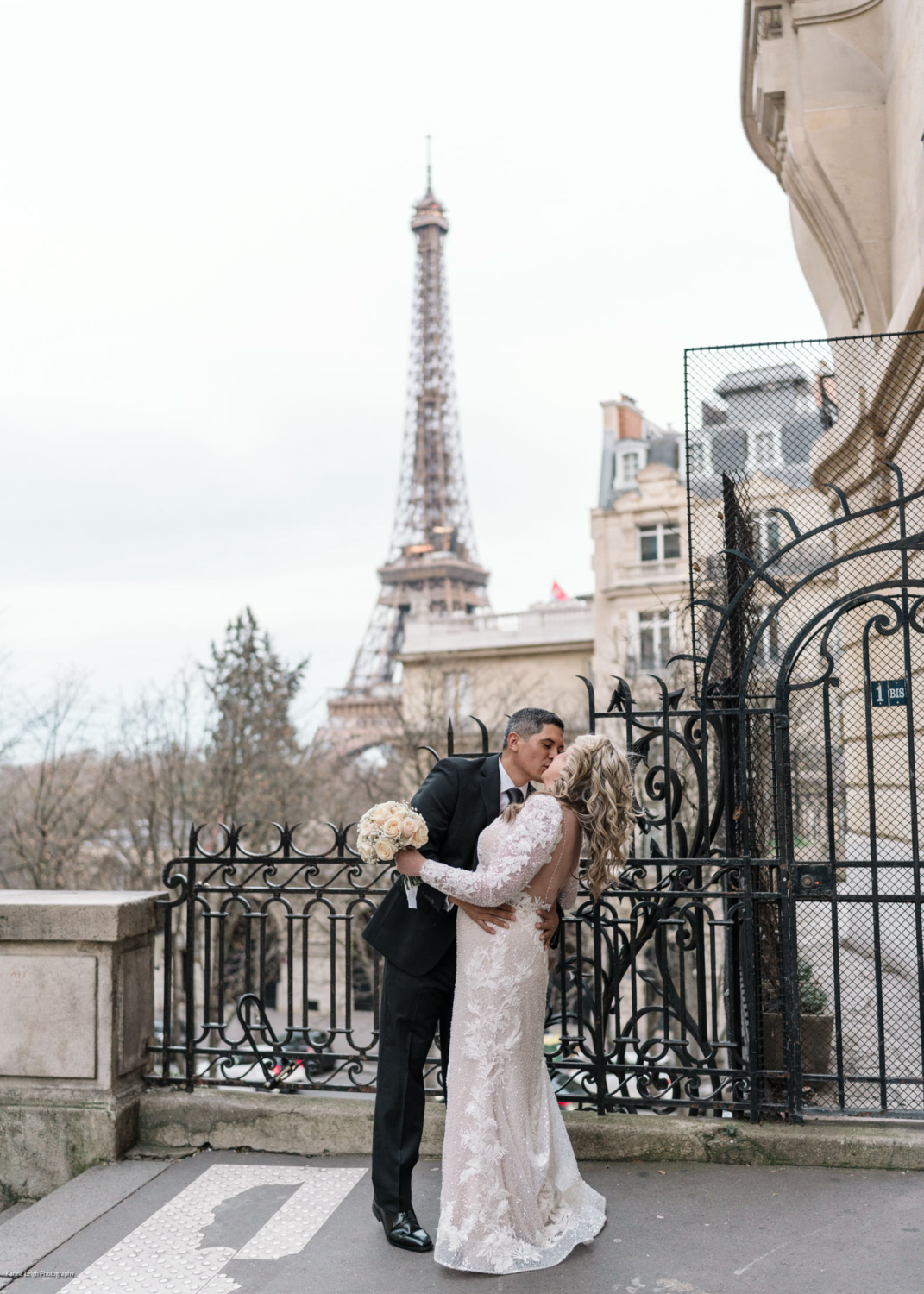 bride and groom kiss passionately with view of eiffel tower in paris