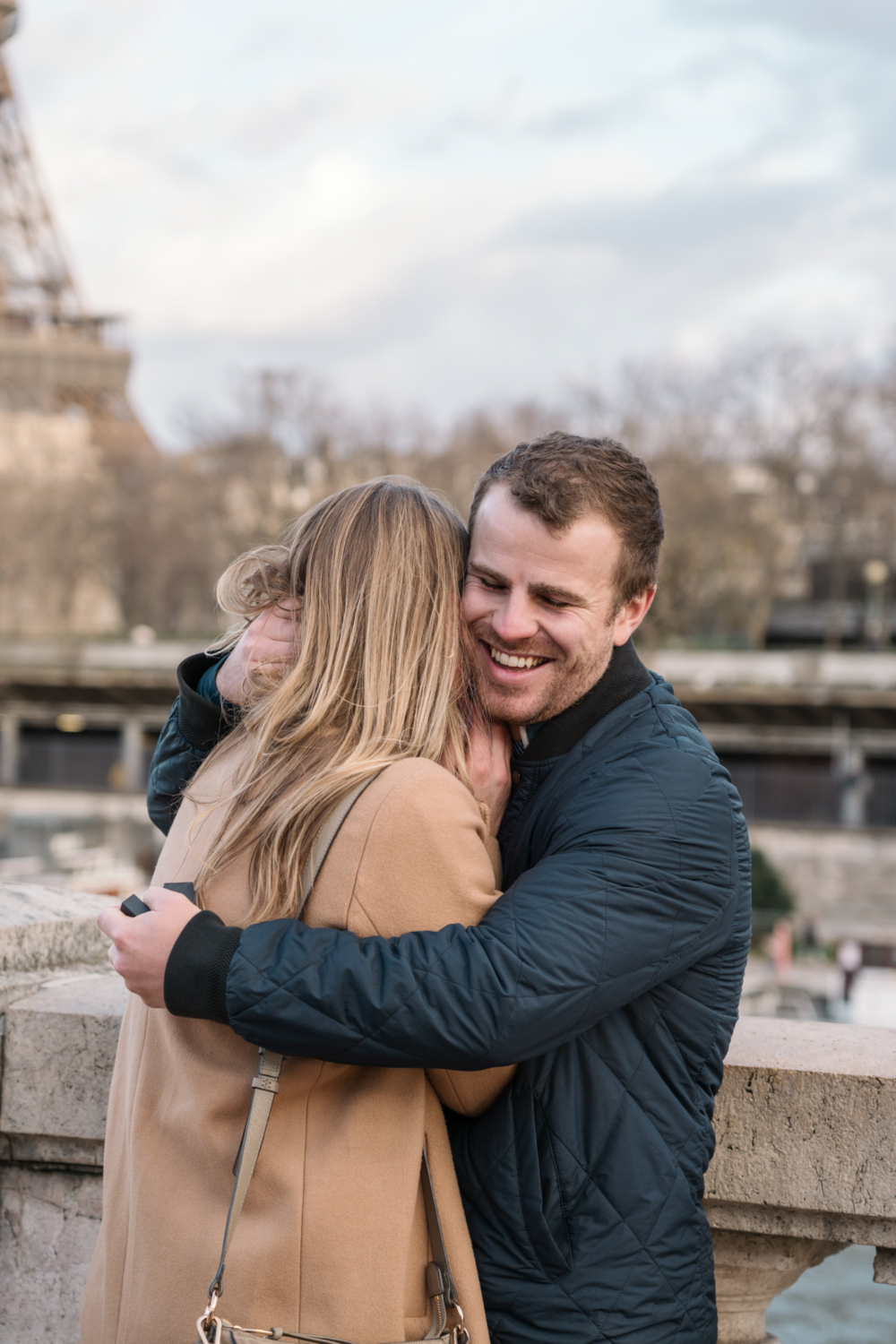 man hugs fiancée in paris after their surprise engagement