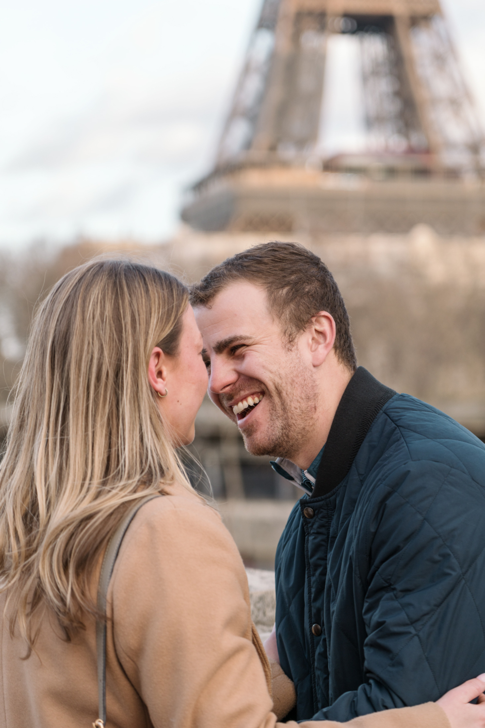 man laughs with joy with view of eiffel tower in paris