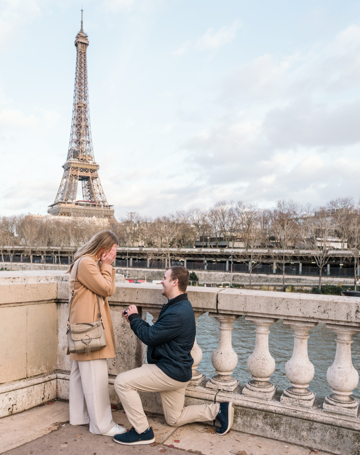 man proposes to woman with view of the eiffel tower in paris france