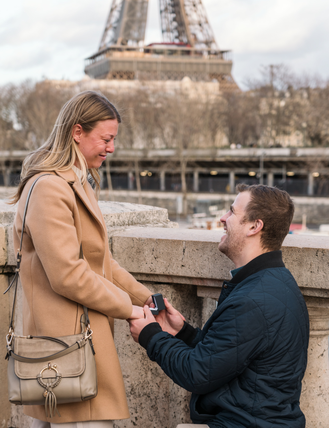 man presents ring to woman with view of eiffel tower in paris france