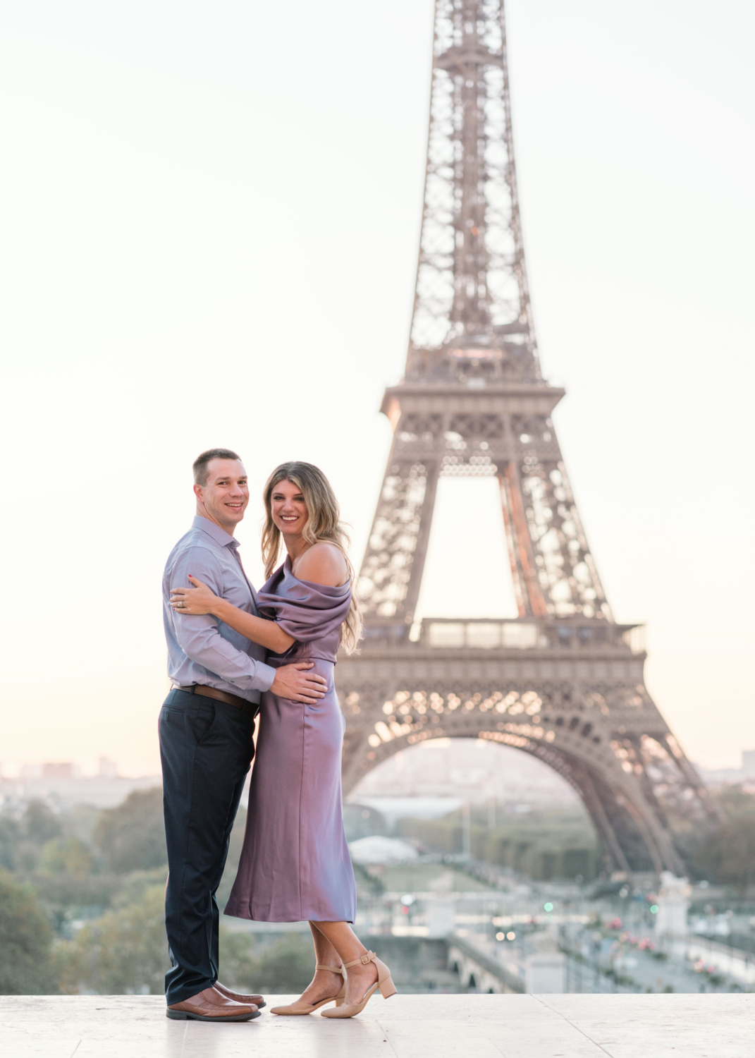 adorable happy couple embrace and smile with view of eiffel tower in paris