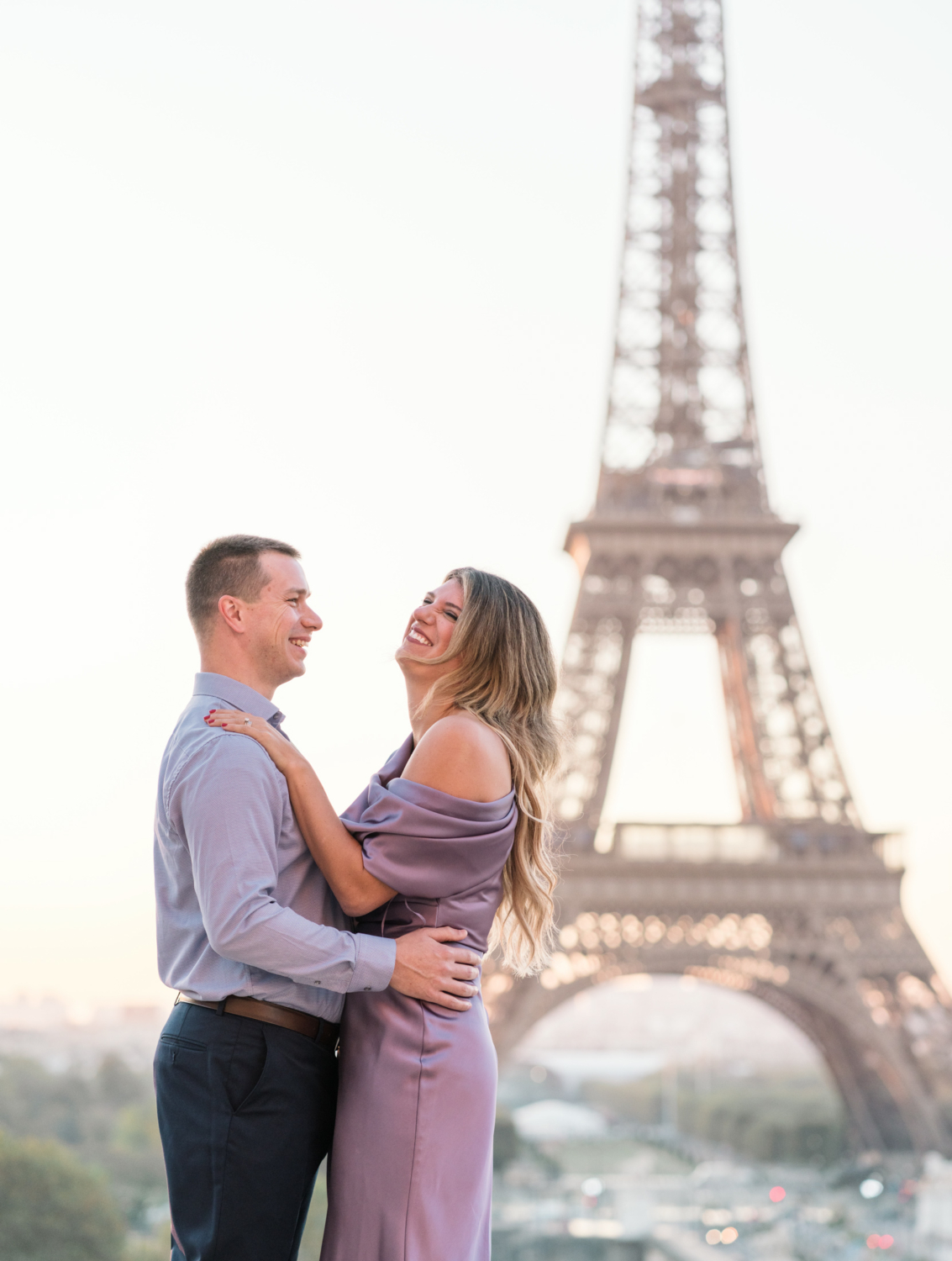 woman laughs with joy at eiffel tower in paris