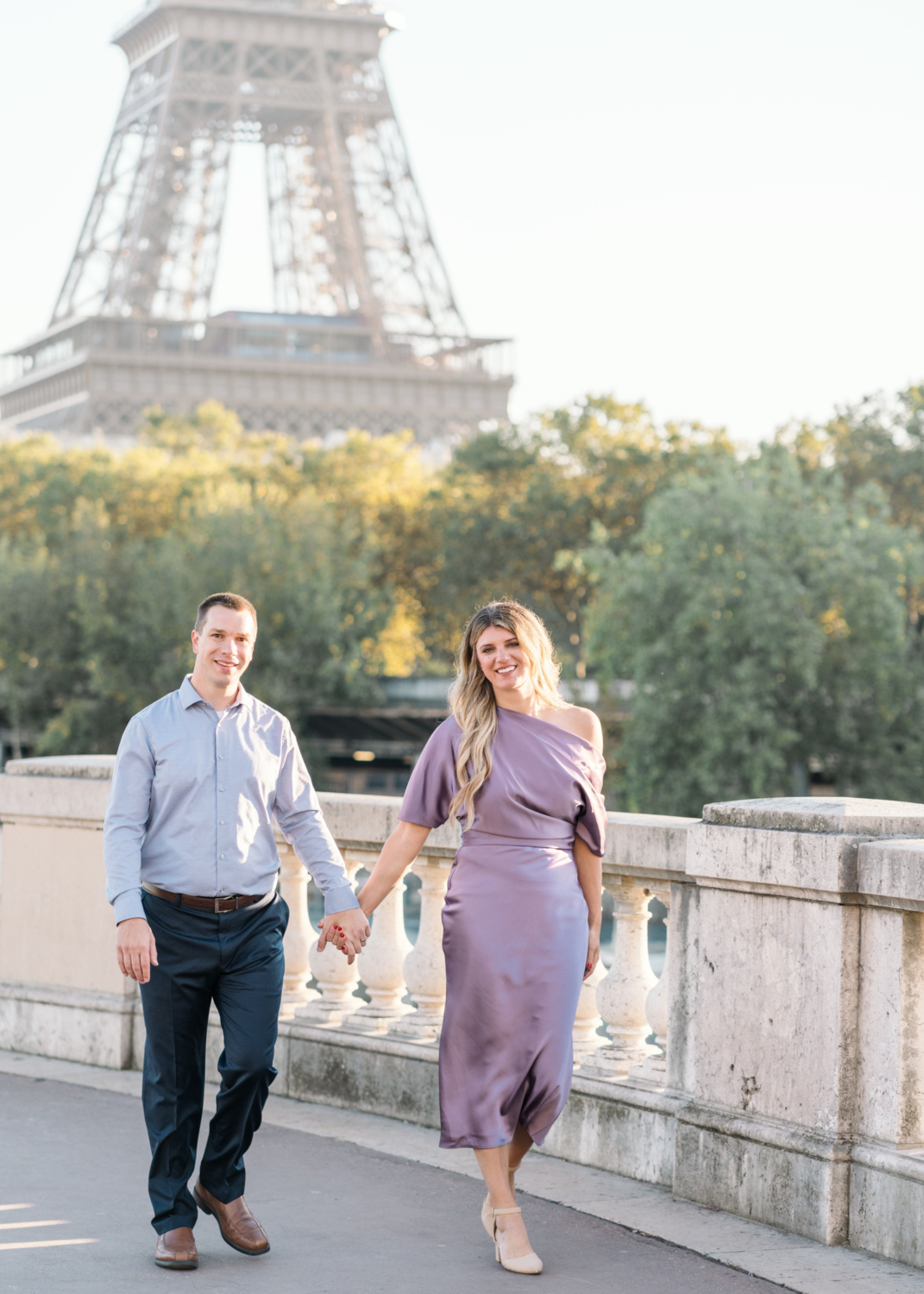 stunning and happy couple walk hand in hand with view of eiffel tower