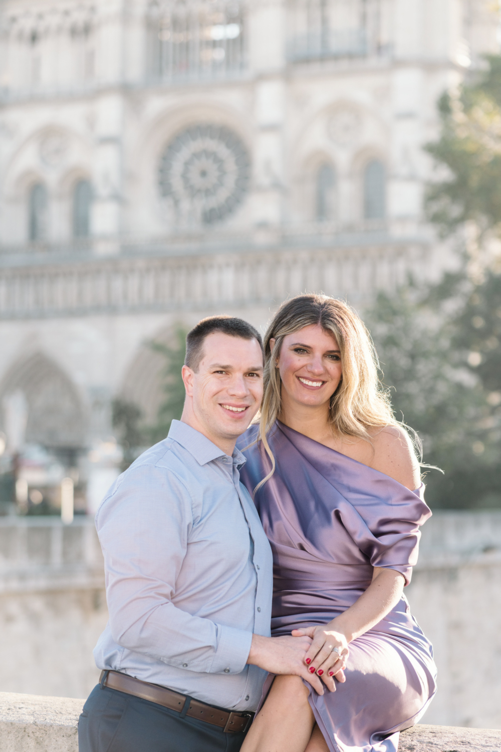 beautiful couple pose outside notre dame cathedral in paris