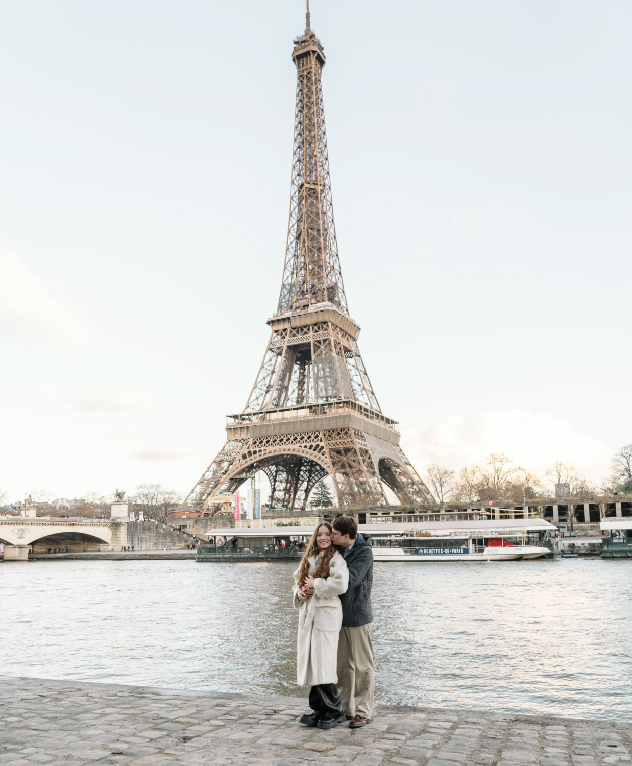 man kisses woman face after engagement at eiffel tower in paris