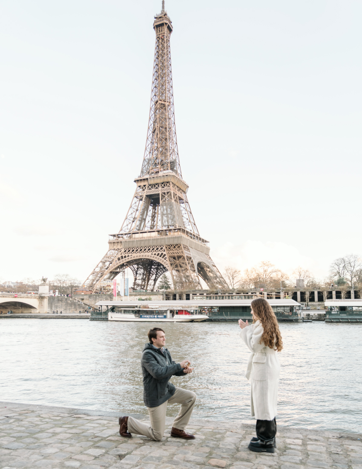 woman is shocked is on one knee proposing with view of eiffel tower