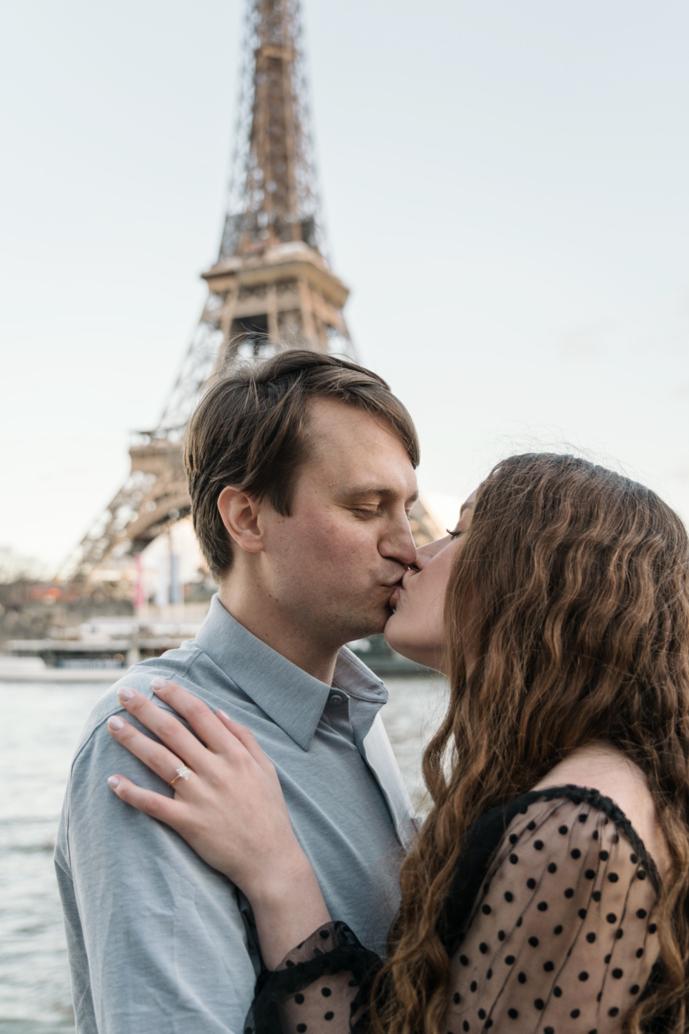 newlywed couple kiss in front of eiffel tower in paris