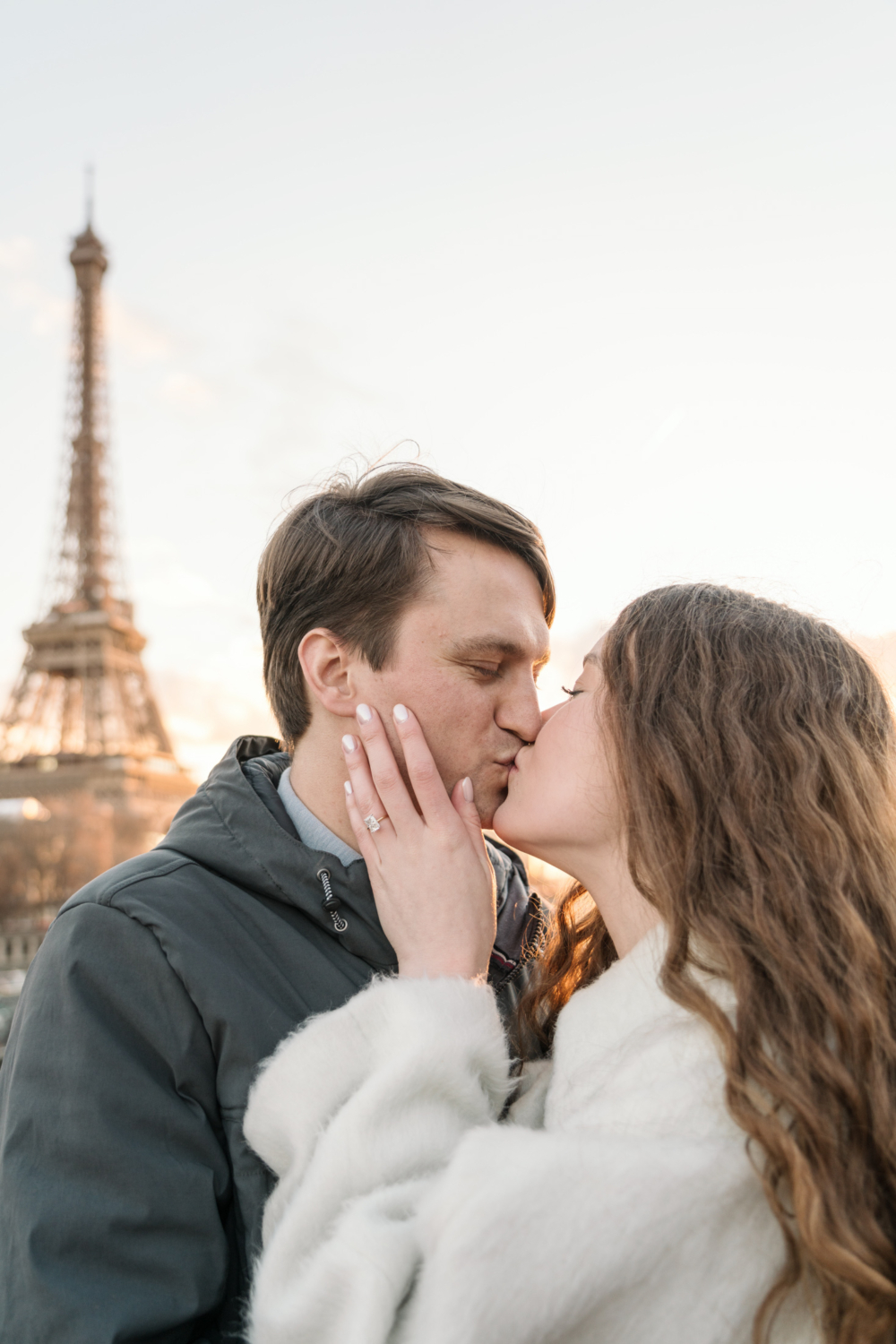 newly engaged coupe kiss passionately with view of eiffel tower