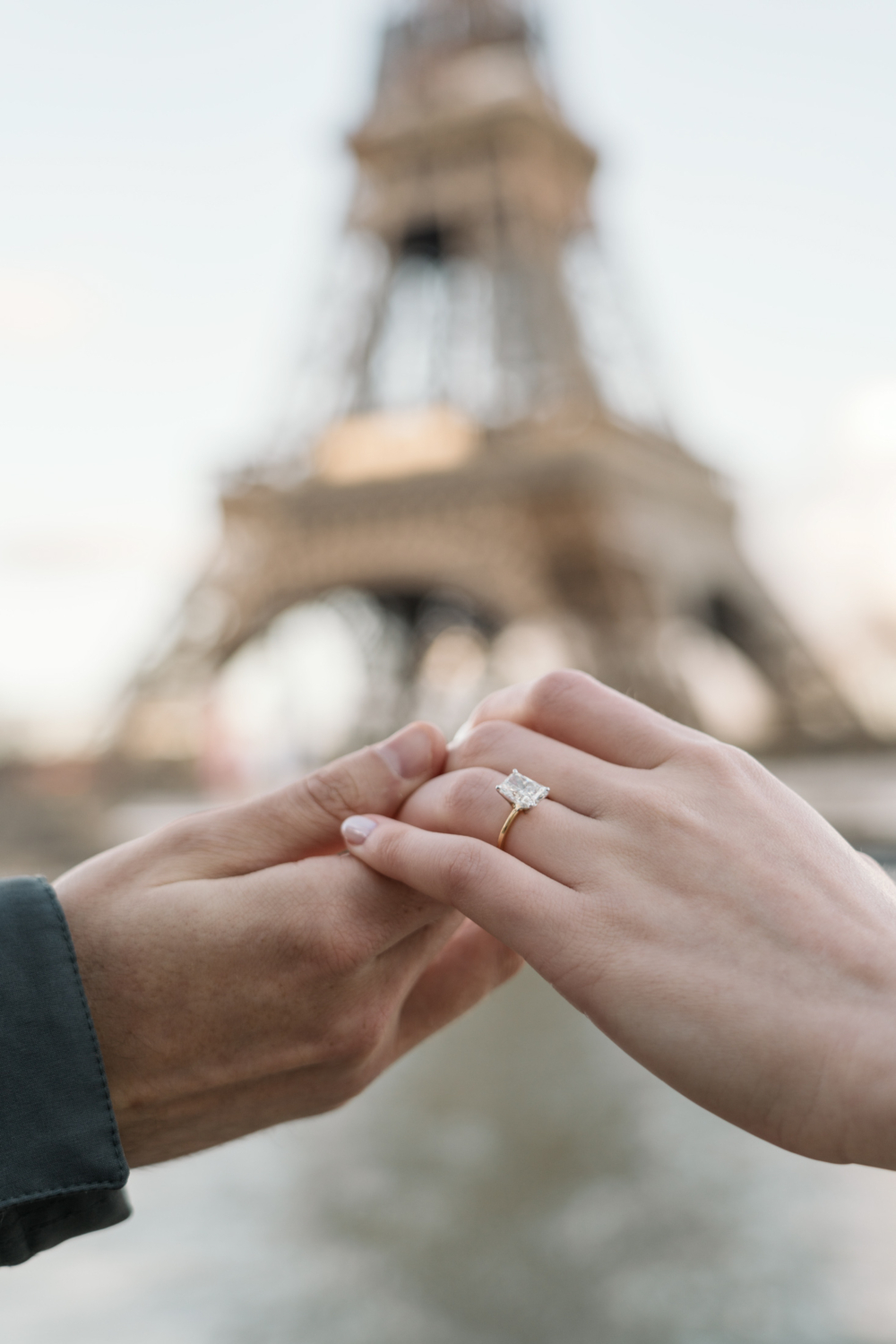 shiny engagement ring with view of eiffel tower