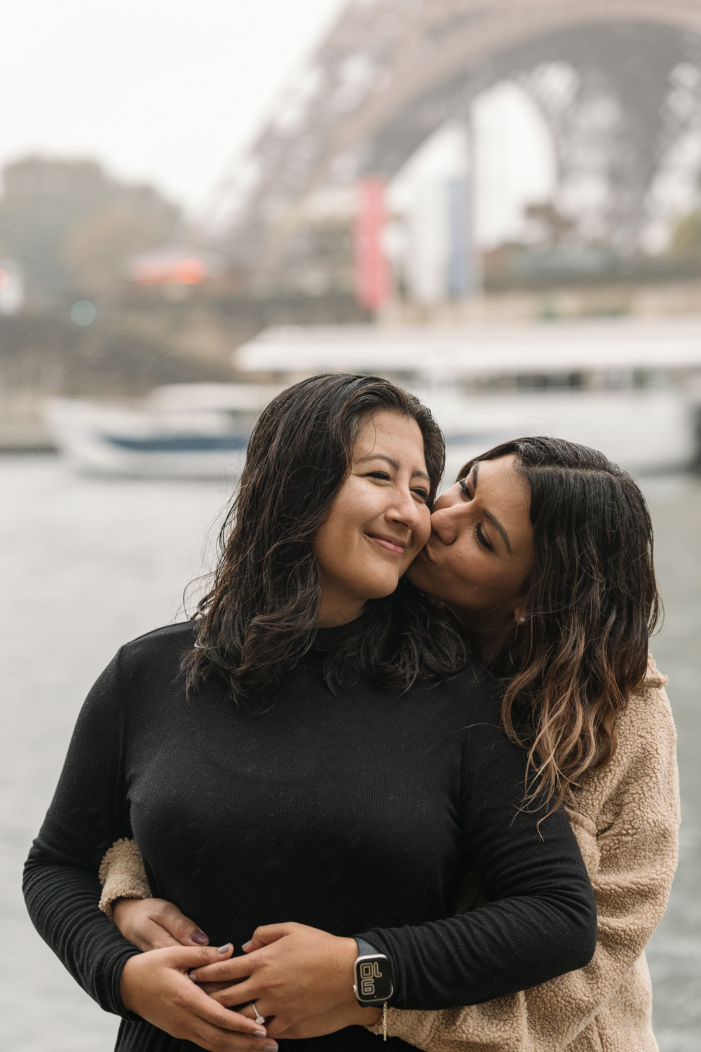 two women embrace and kiss after surprise proposal in paris