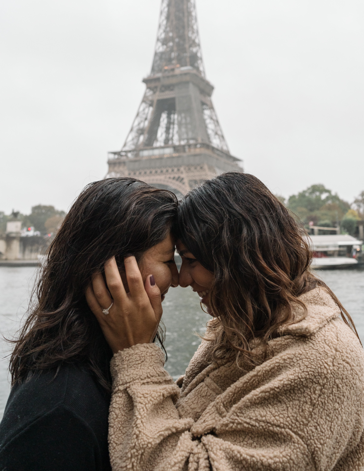 two women smile and put their heads together after their surprise oroposal in paris