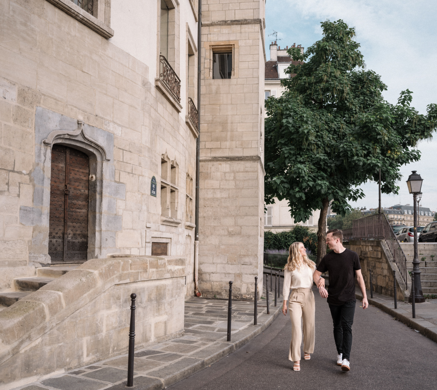 cute young newly engaged couple walk arm in arm in the latin quarter in paris