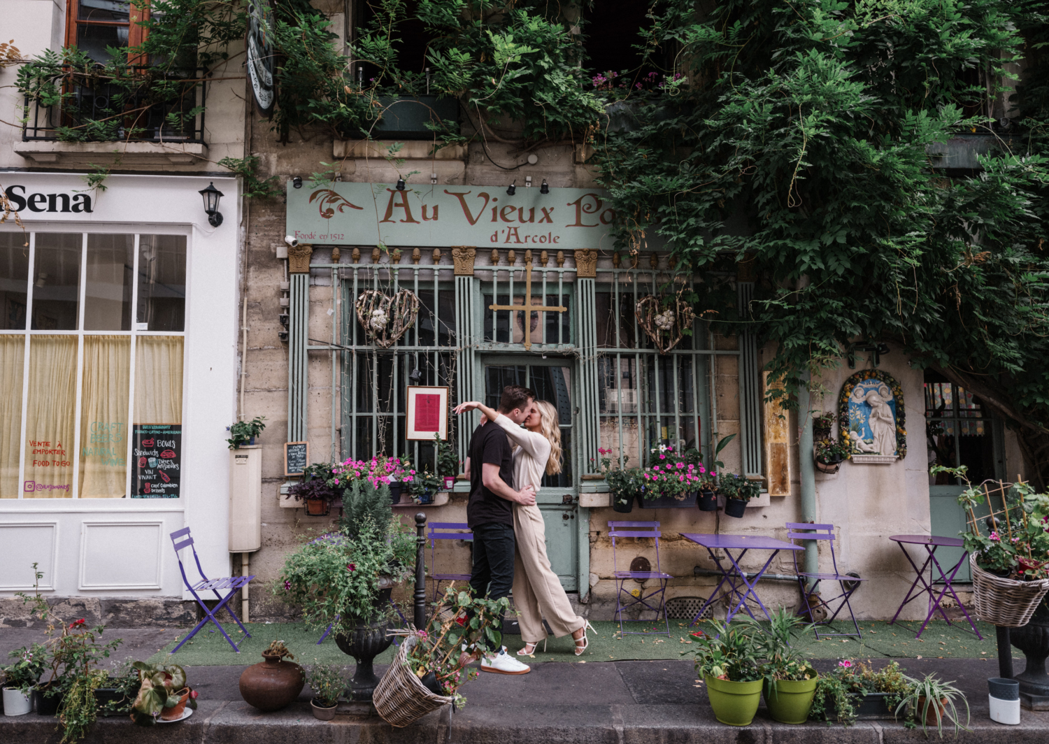 cute young newly engaged couple kiss in front of flower shop  during Engagement Photos In Paris