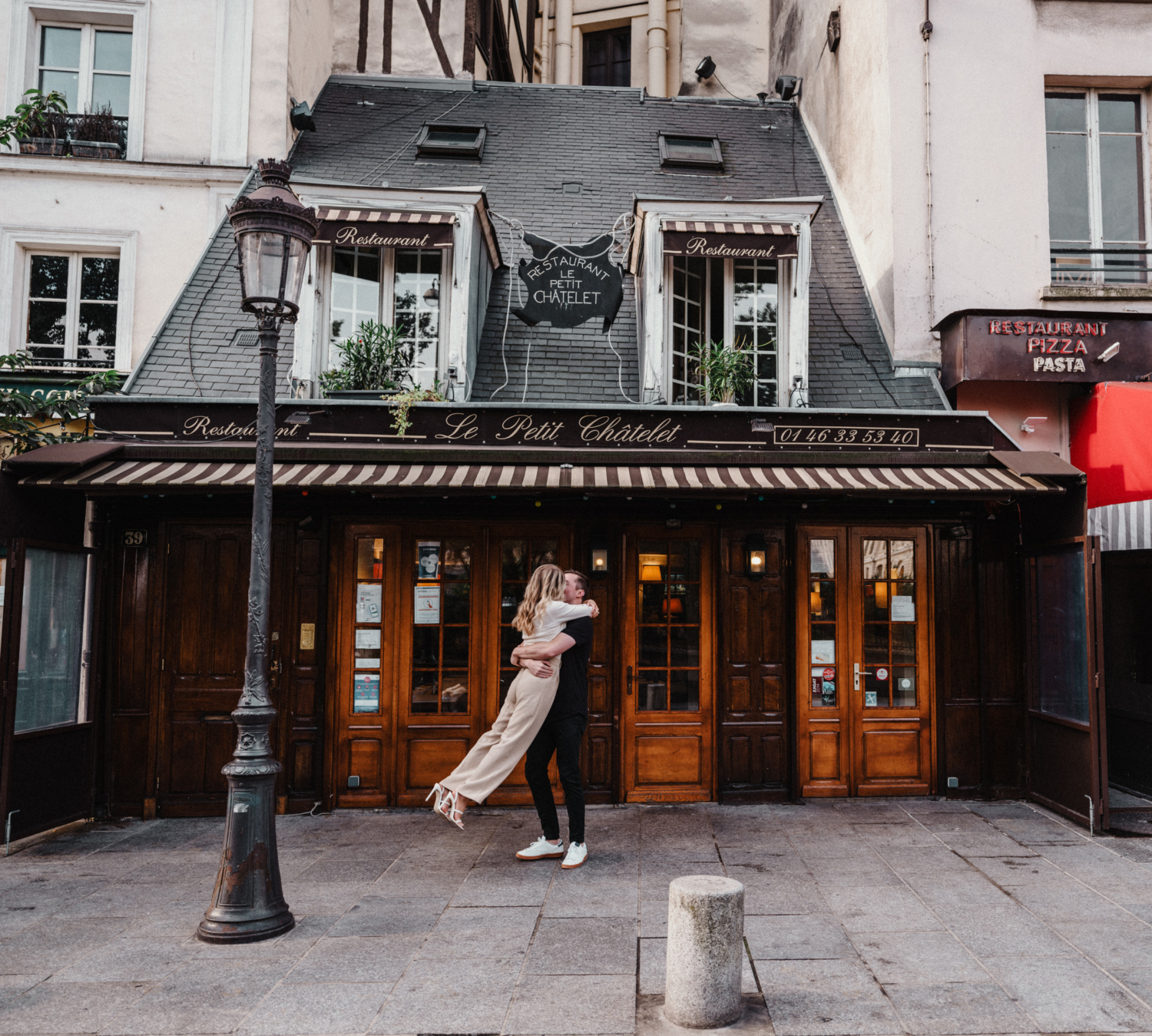 man swings woman during engagement photoshoot in charming neighborhood in paris