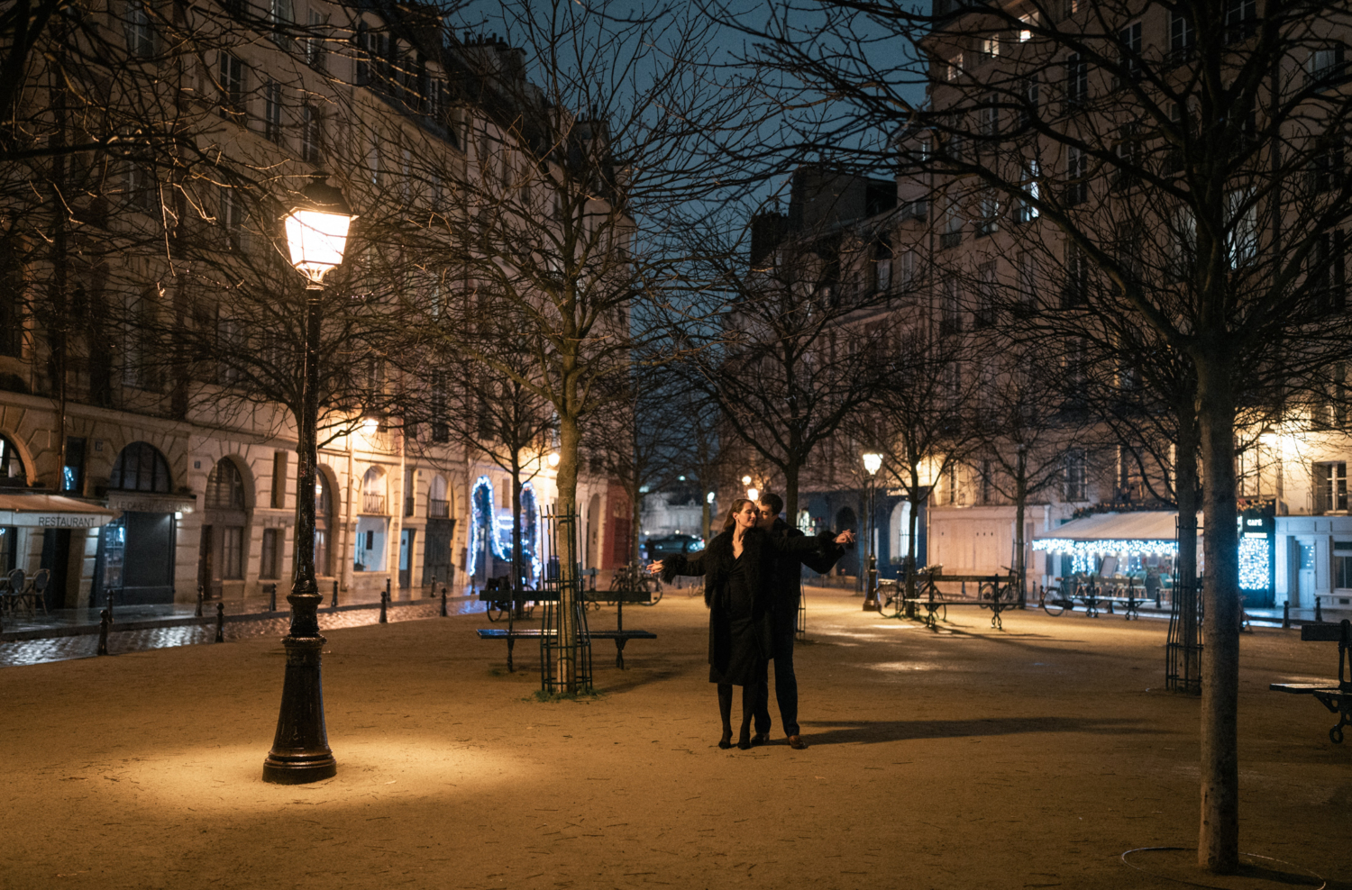 newly engaged couple embrace at place dauphine in paris