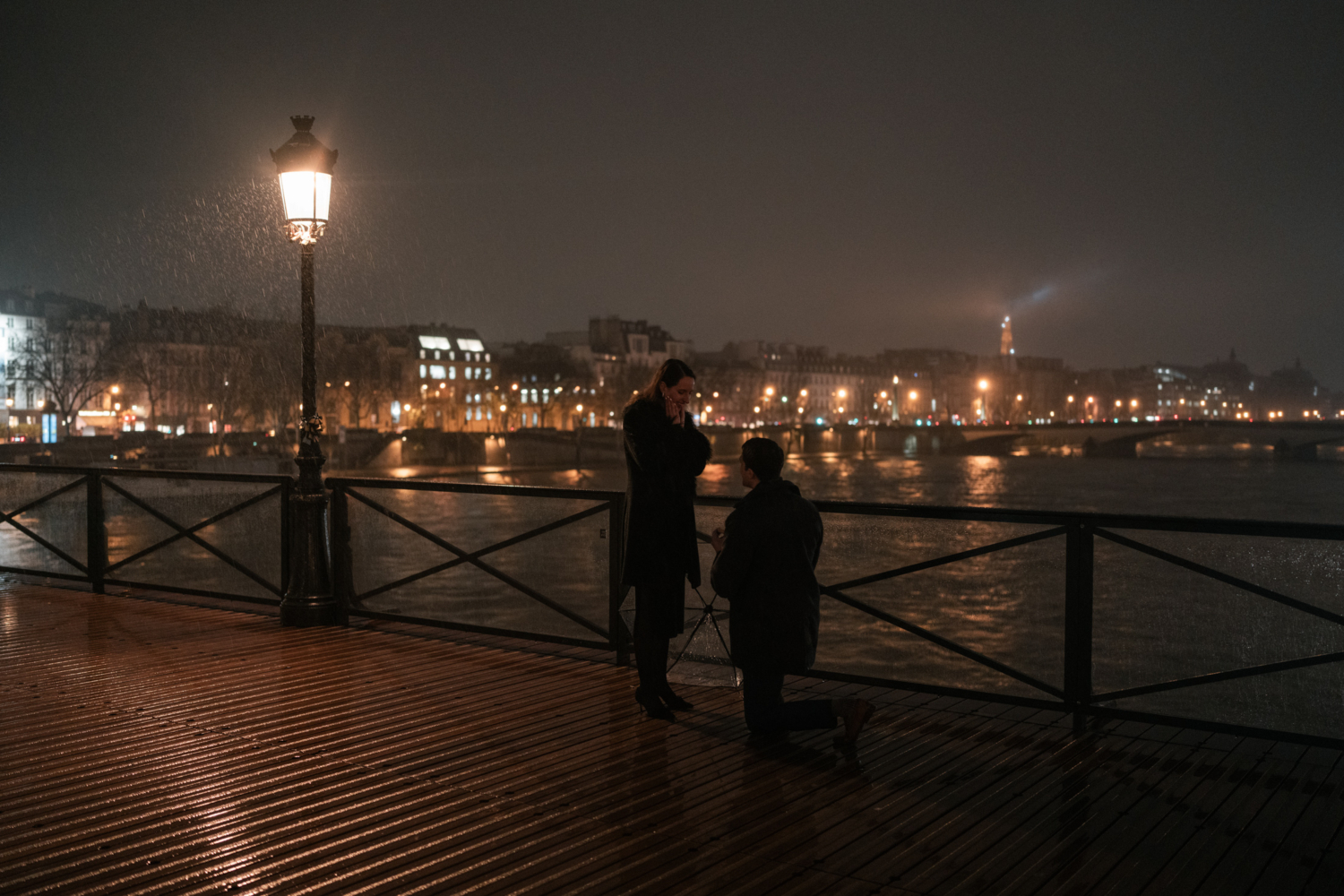 man on one knee presents diamond ring to woman in paris