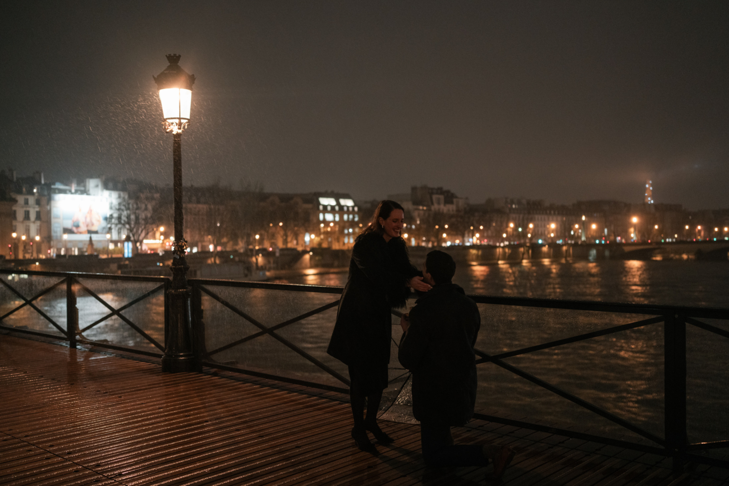 woman is surprised as man on one knee proposes marriage in paris