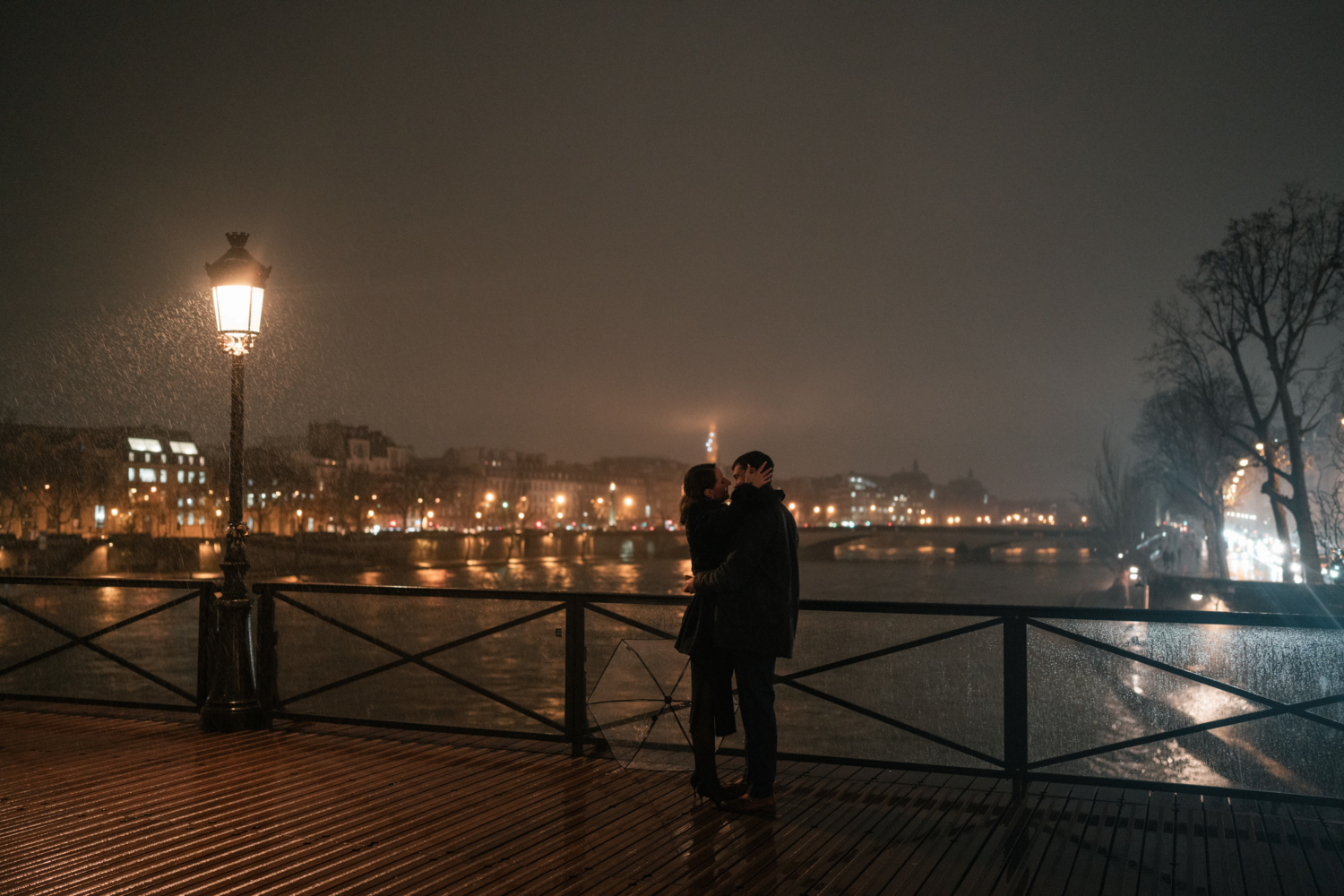 newly engaged couple embace with view of eiffel tower in background in paris