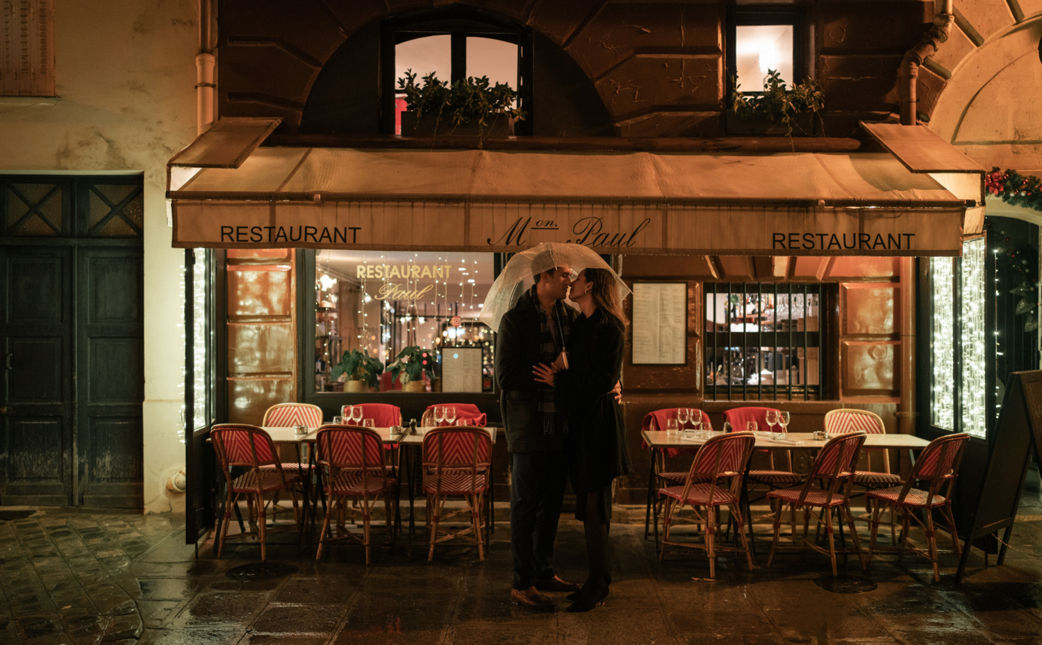 newly engaged couple pose in front of cute restaurant in paris