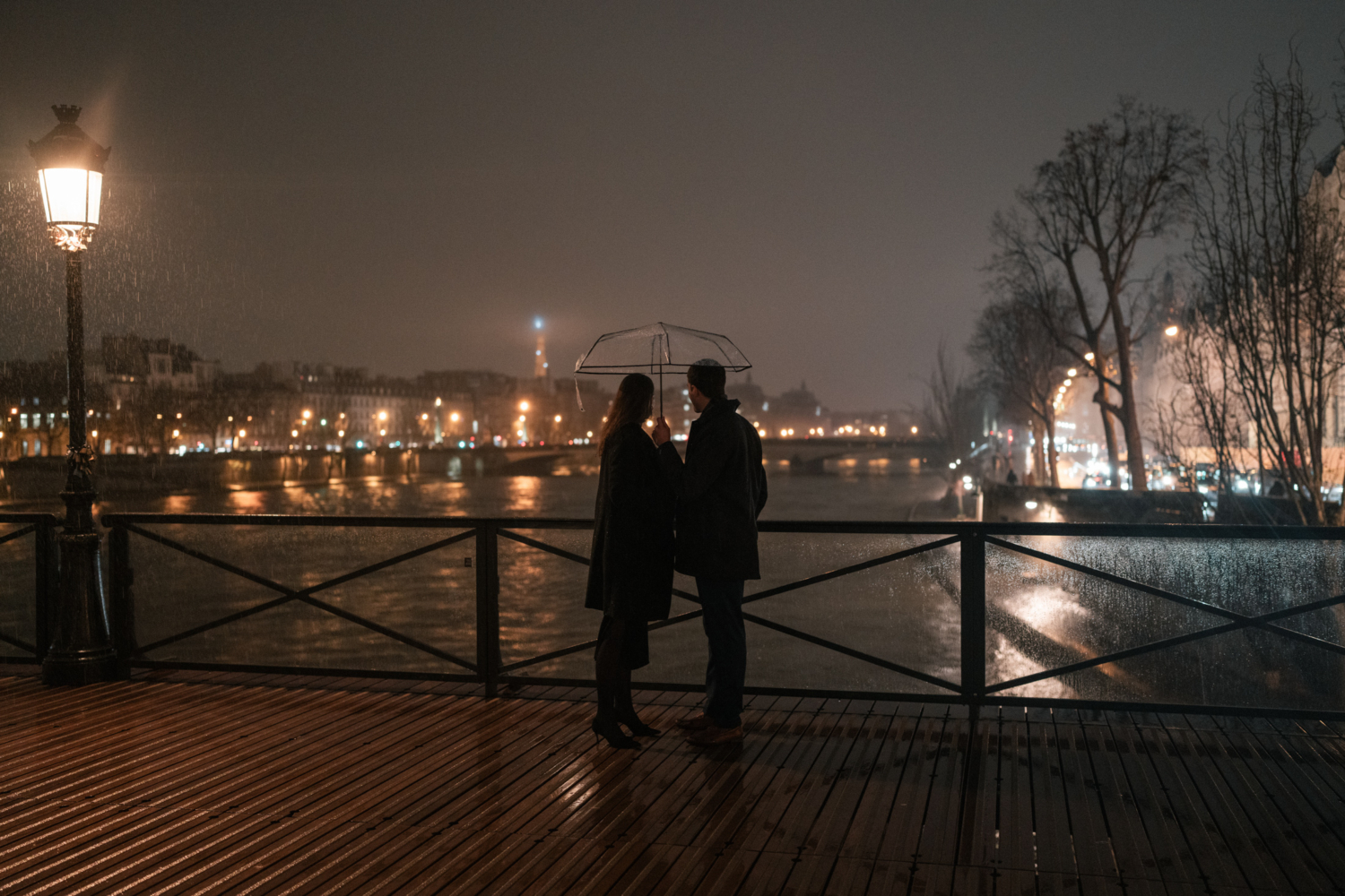 couples look at the eiffel tower shimmering at night in paris france